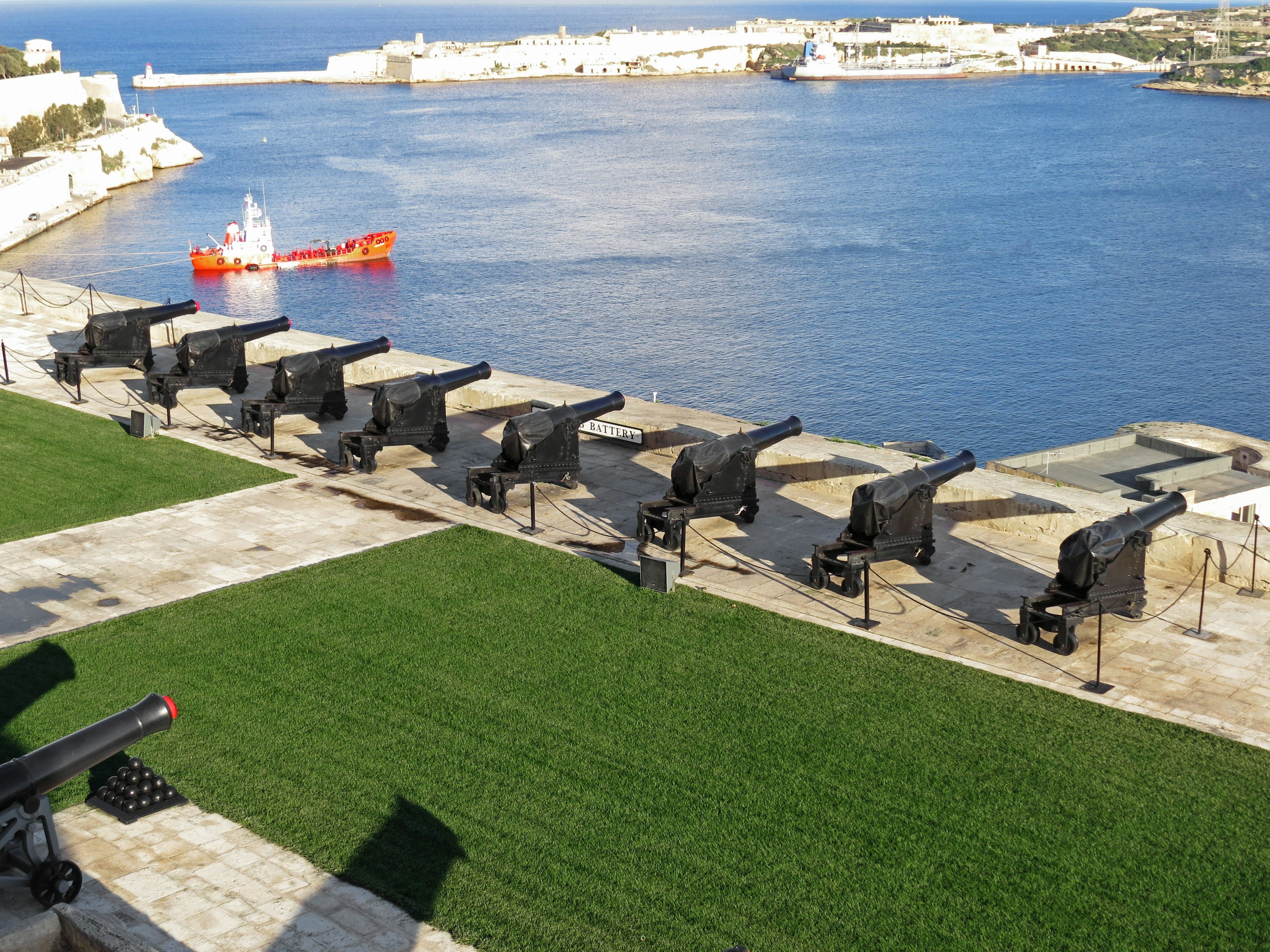 Row of black cannons along the coast overlooking the blue sea