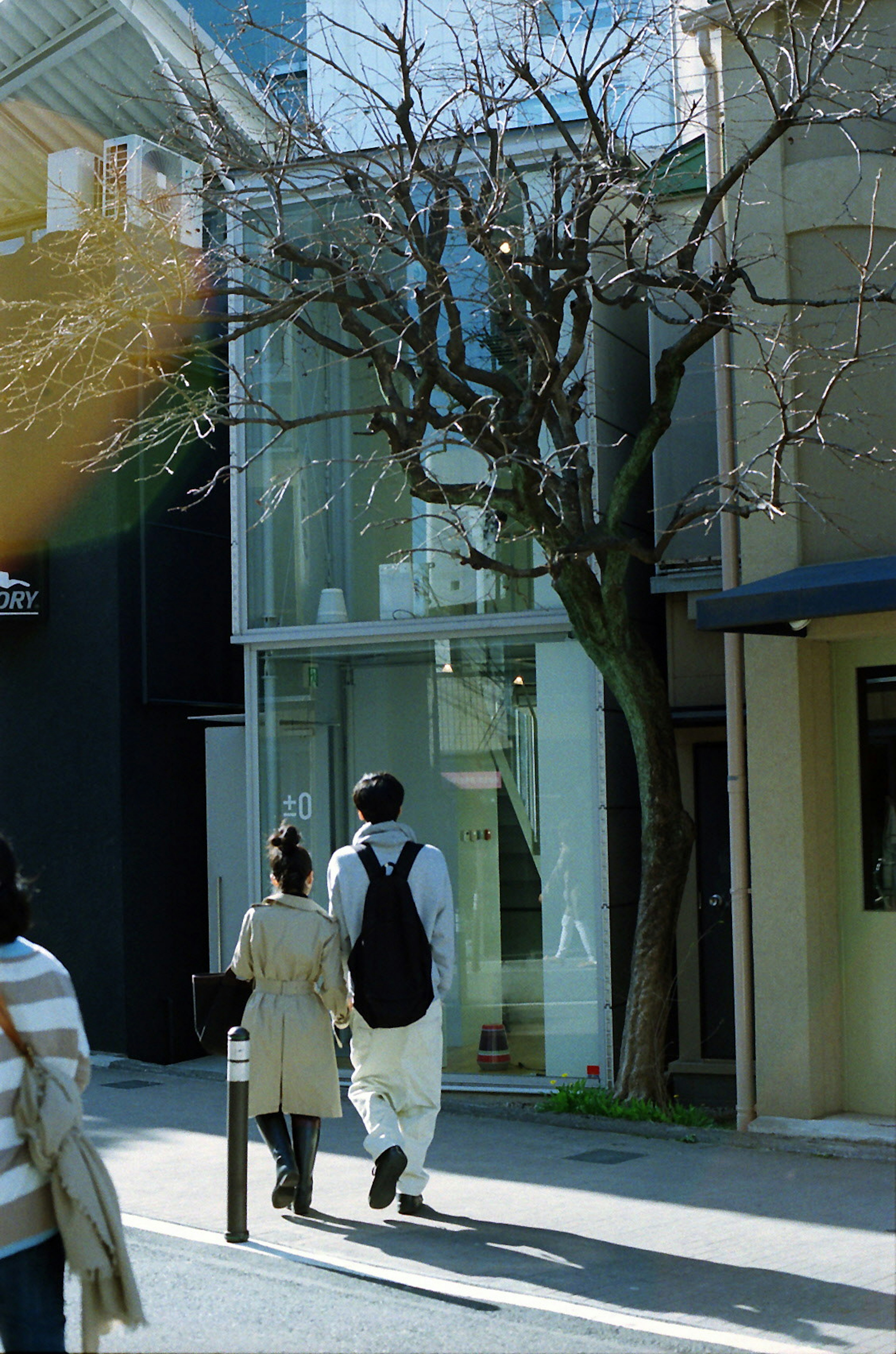 Couple walking past a modern glass building