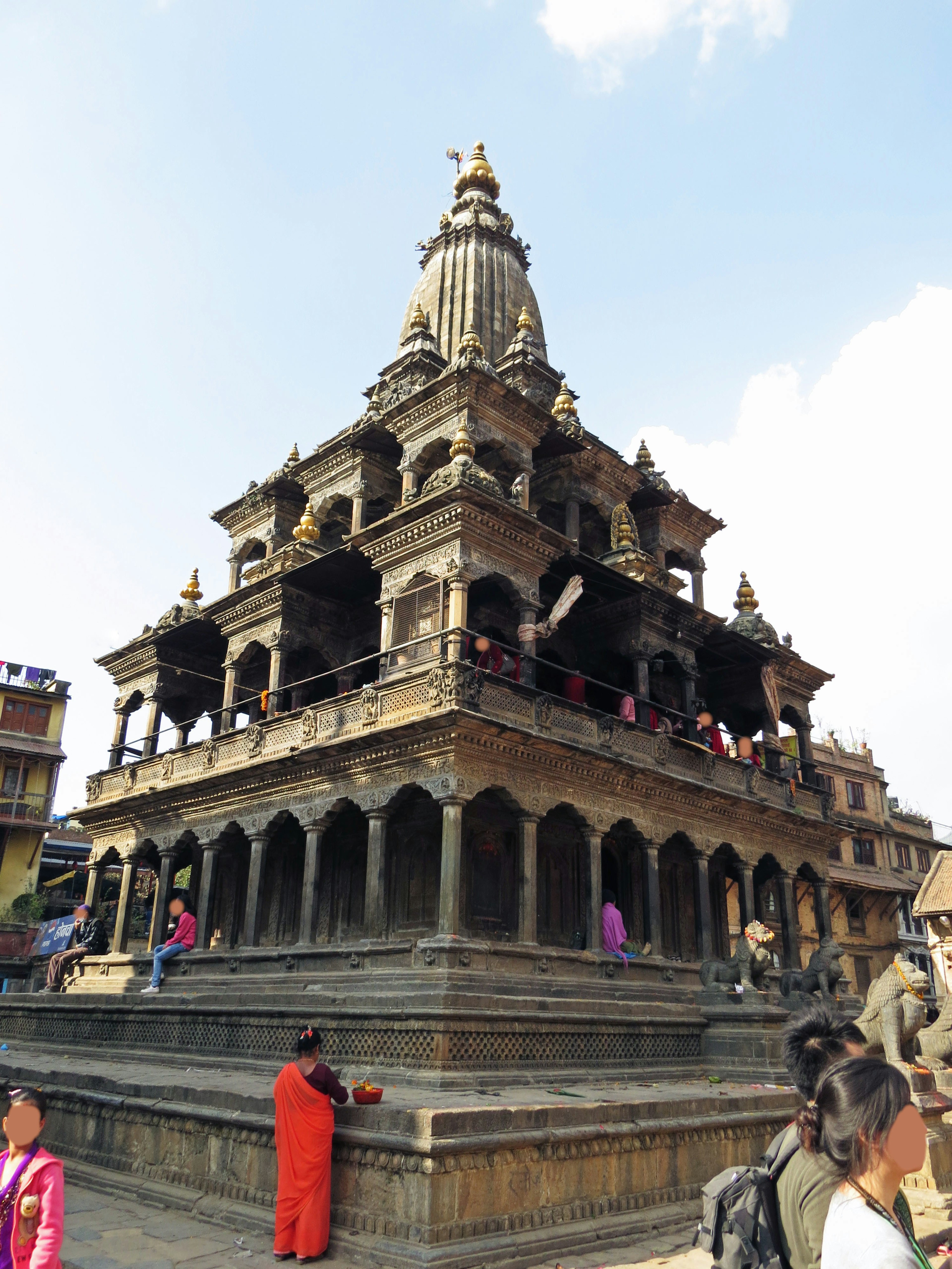 Una hermosa estructura de templo bajo un cielo azul con muchas personas alrededor