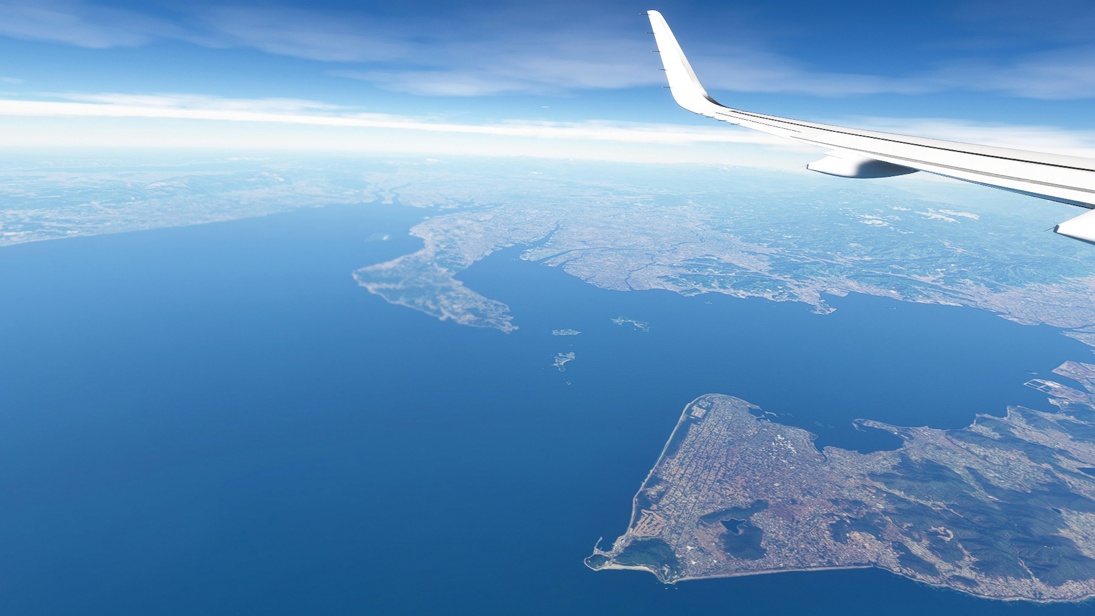 飛行機の翼越しに広がる海と島々の風景