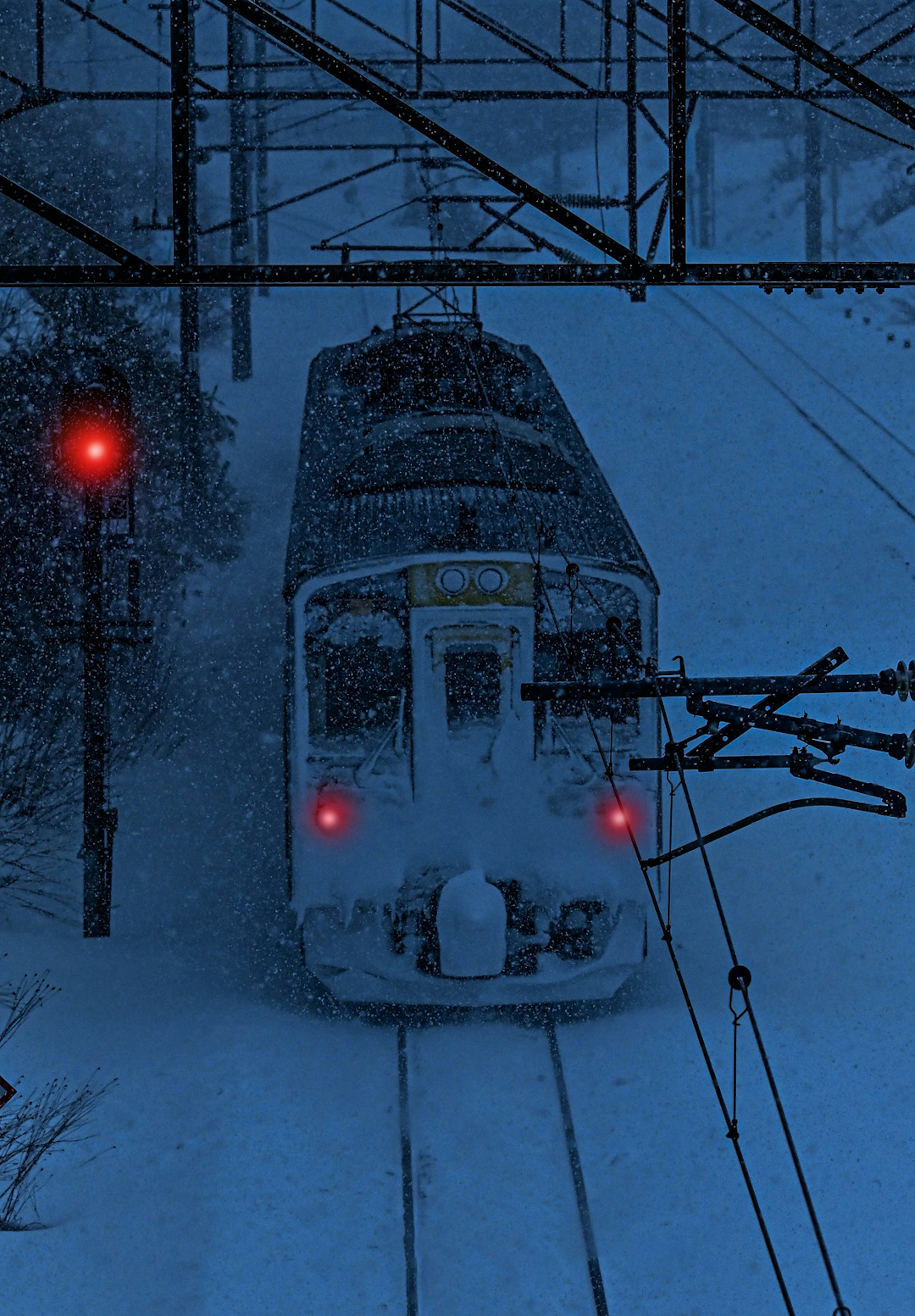 Treno che naviga attraverso una forte nevicata con un segnale rosso