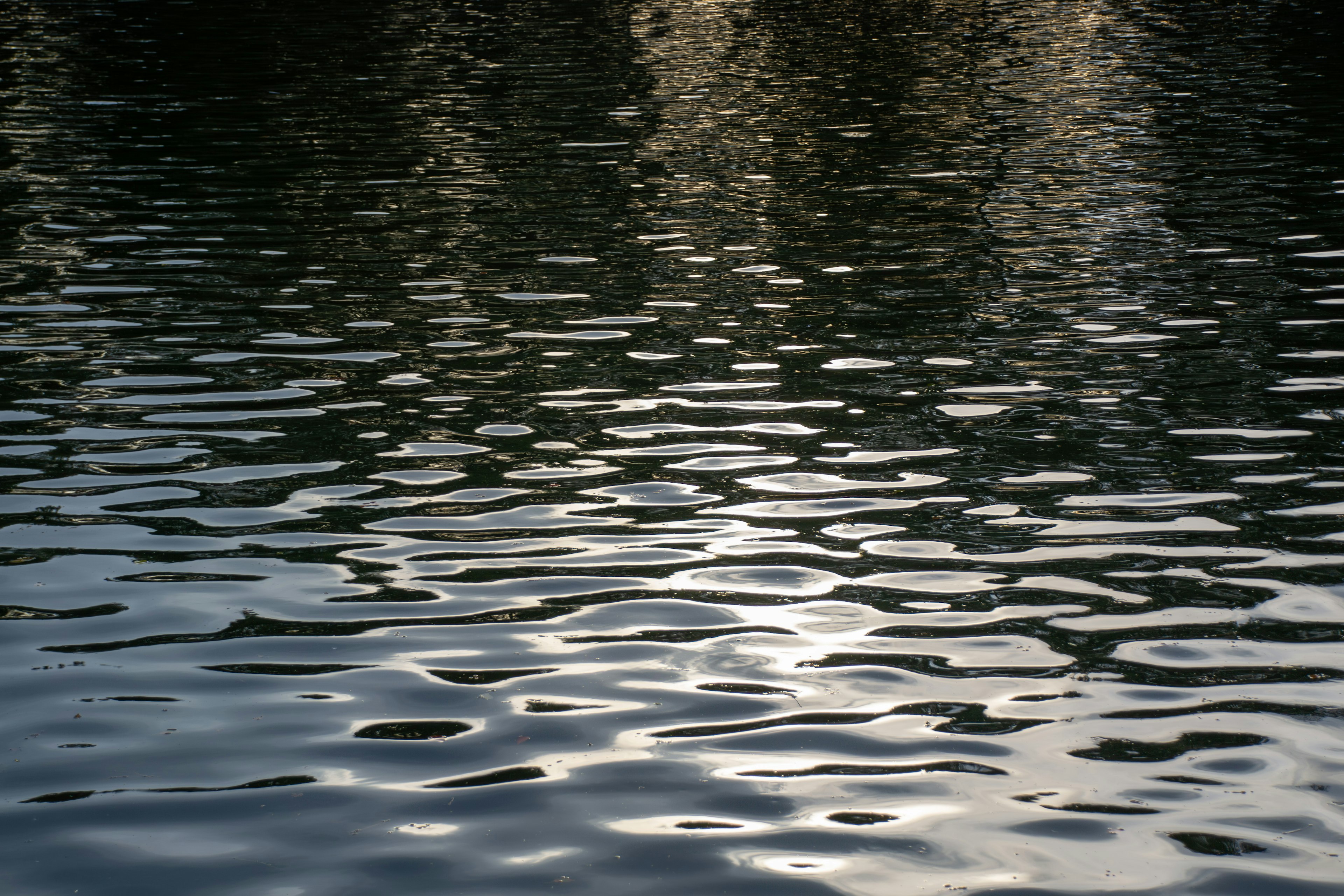 Permukaan danau tenang dengan refleksi cahaya