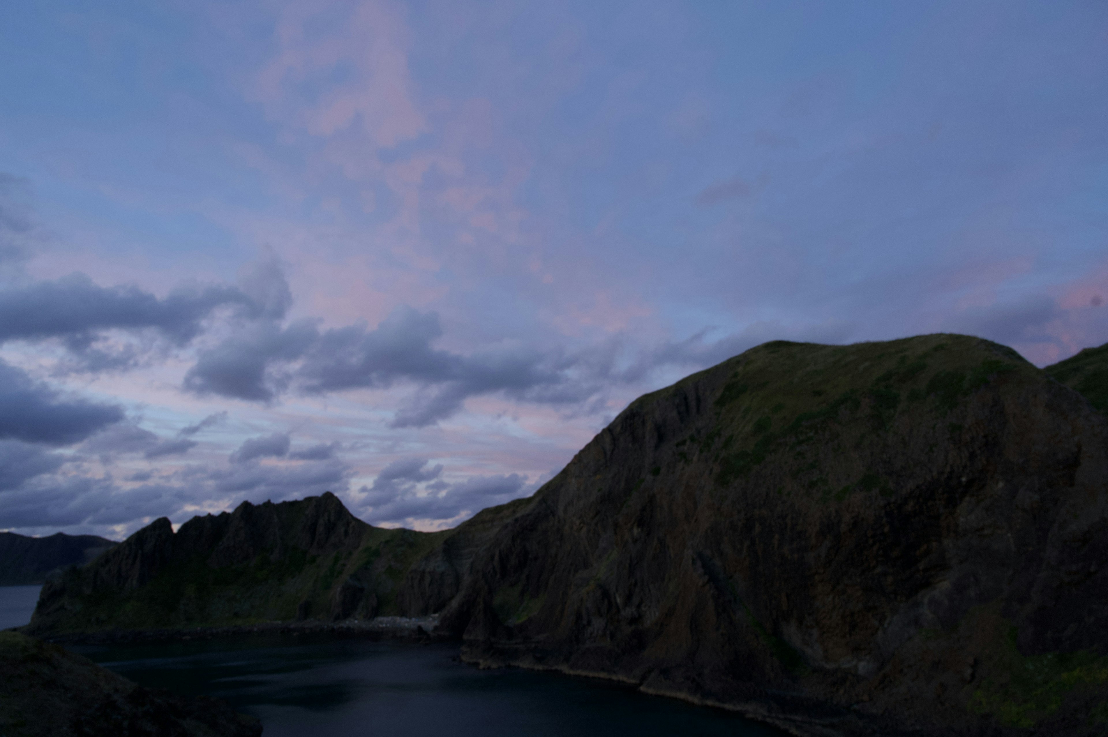 Paesaggio costiero con cielo blu e nuvole rosa morbide