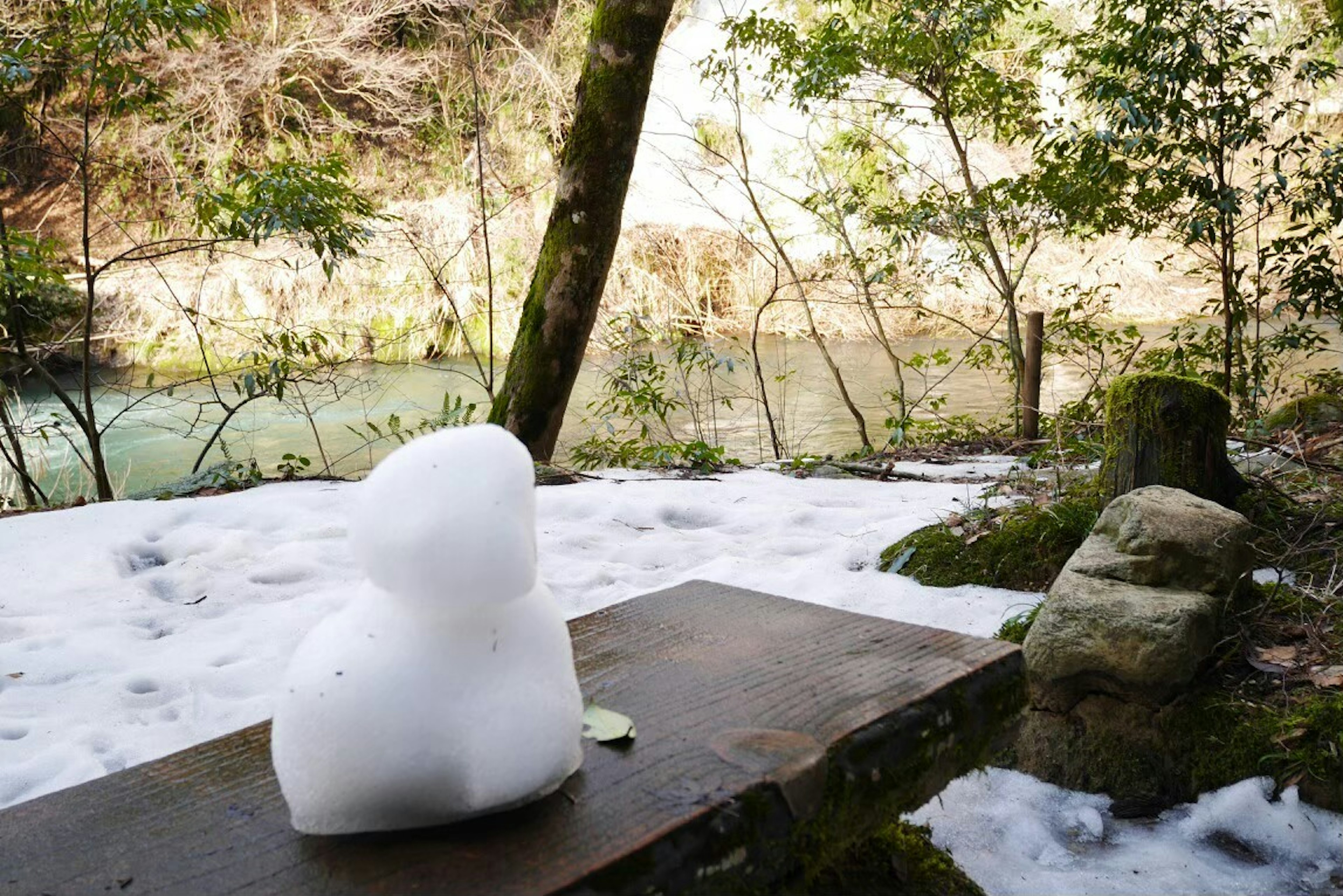 Schneeskulptur neben einem Fluss in einer Winterlandschaft