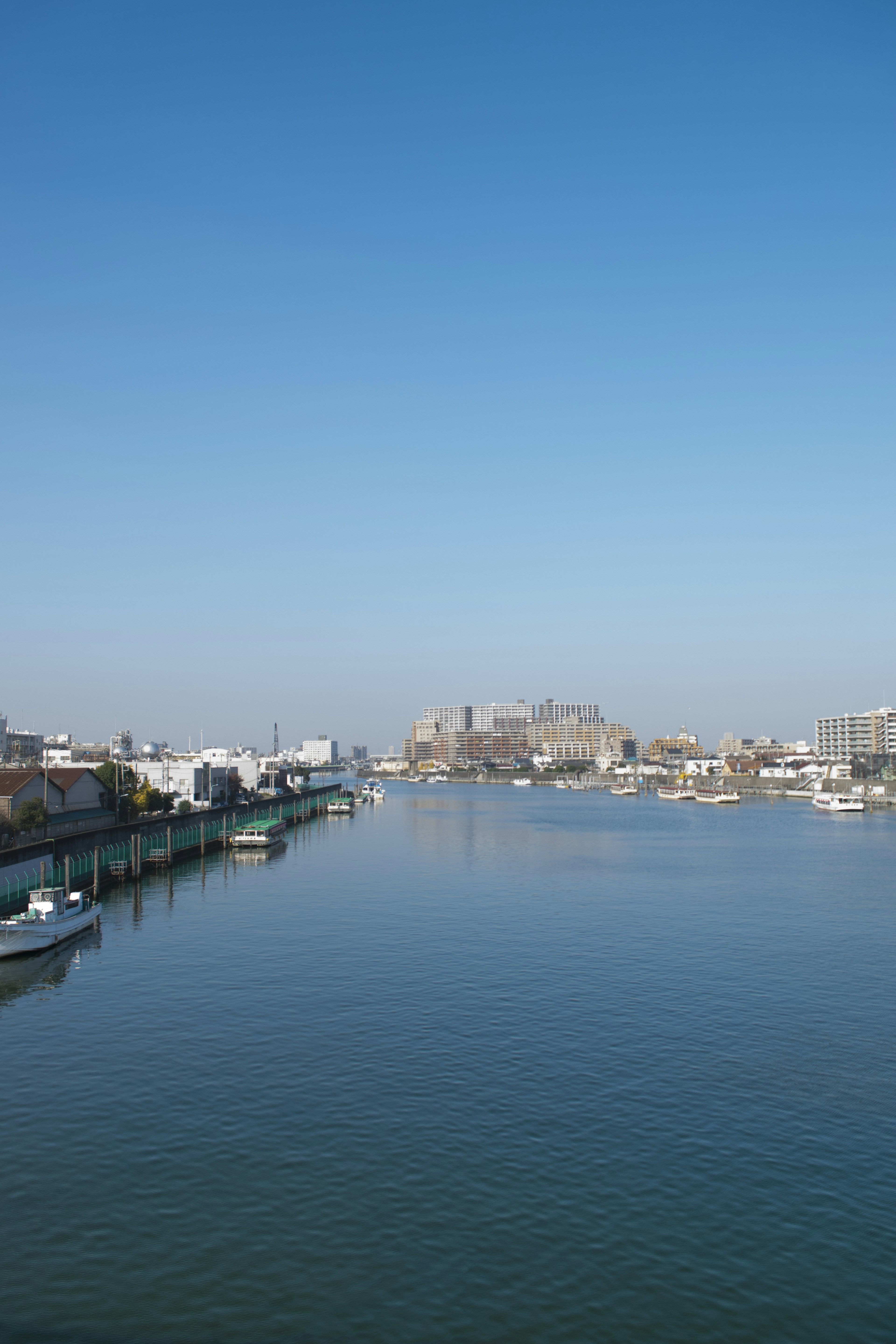 Scenic view of a river with boats under a clear blue sky