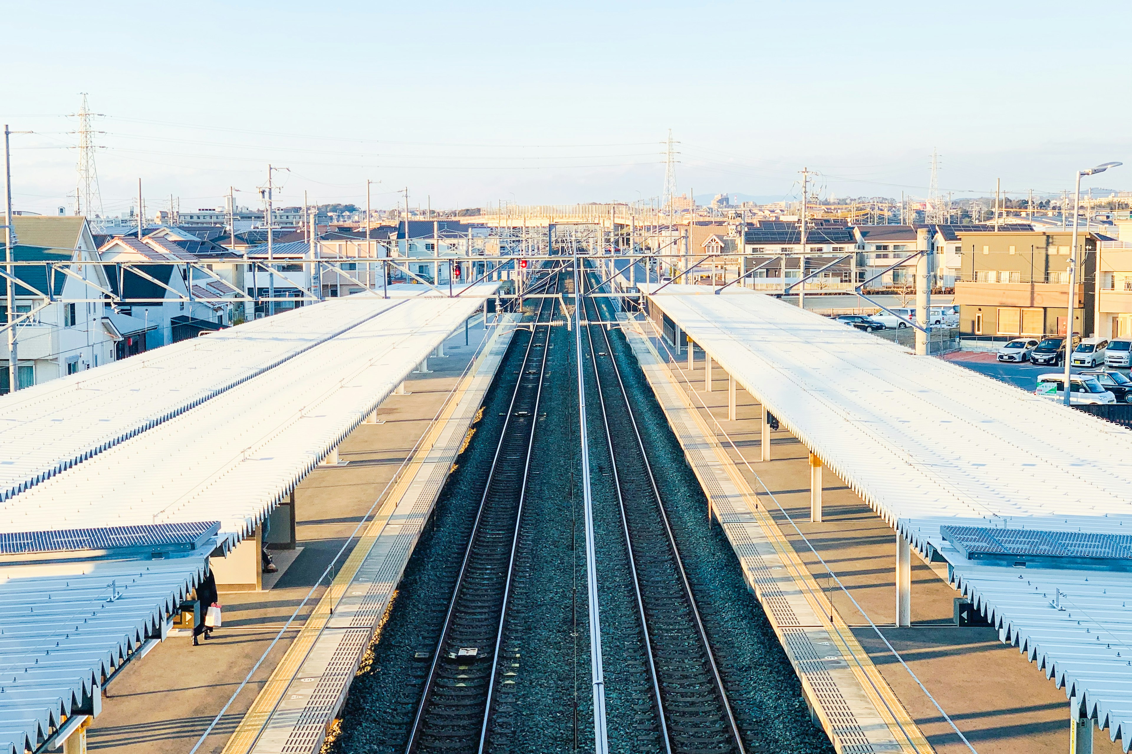 Vue large d'une plateforme de gare et de voies ferrées