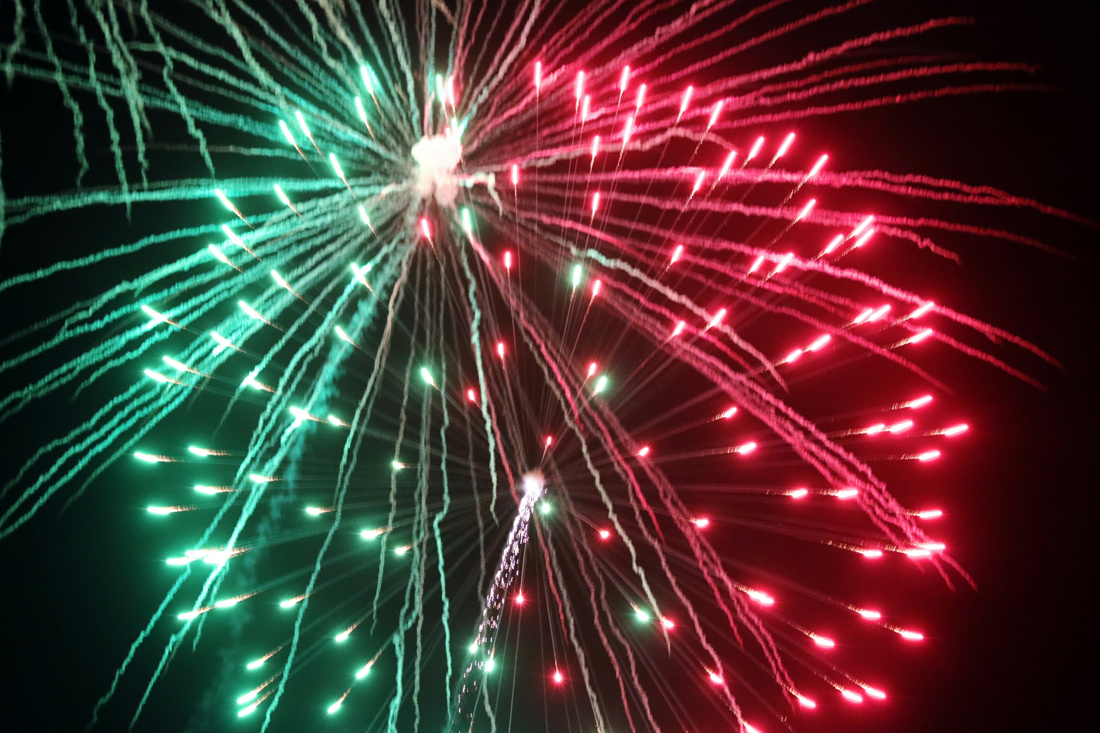 A beautiful display of red and green fireworks in the night sky