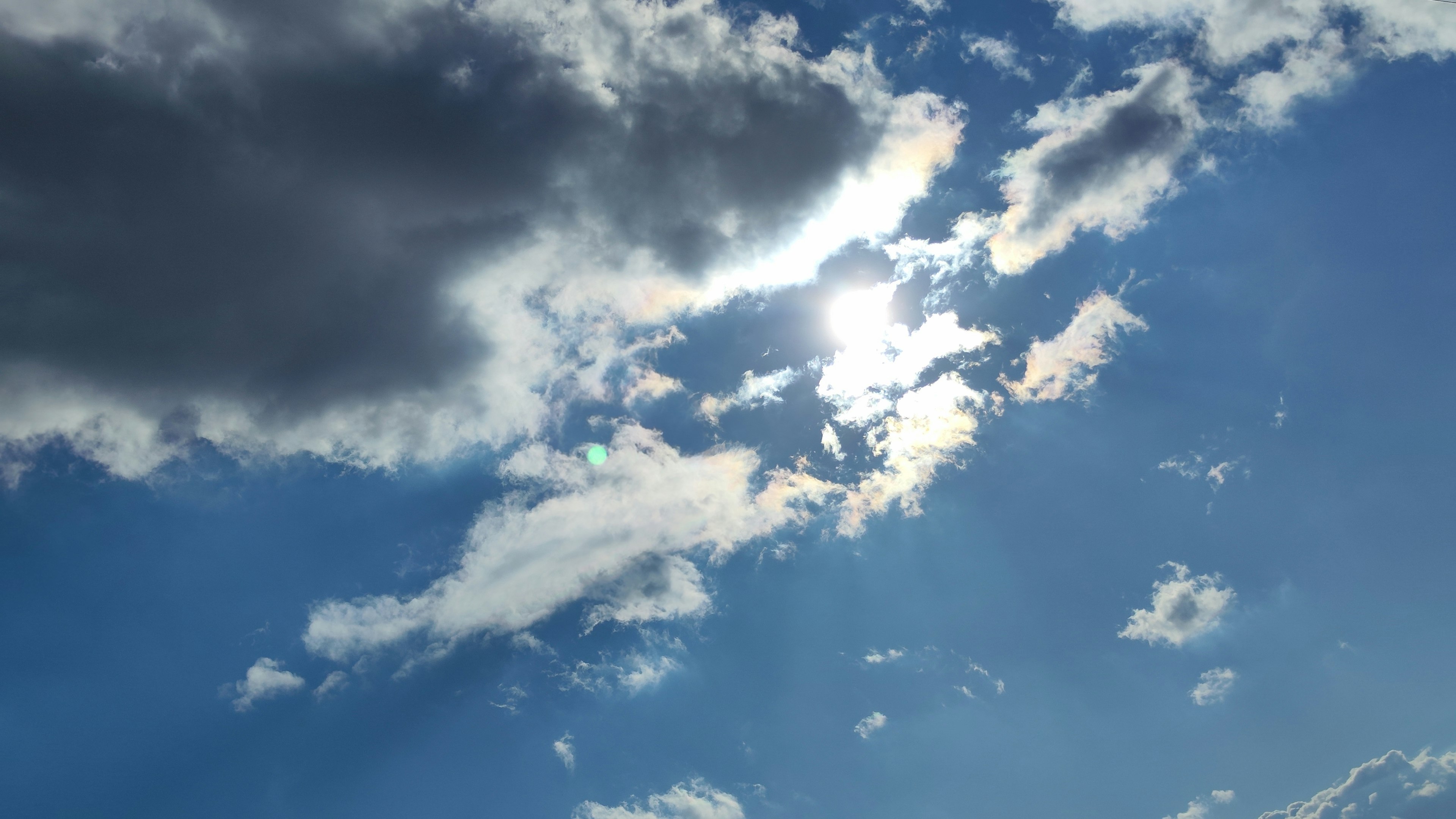 Luz del sol brillando a través de nubes en un cielo azul