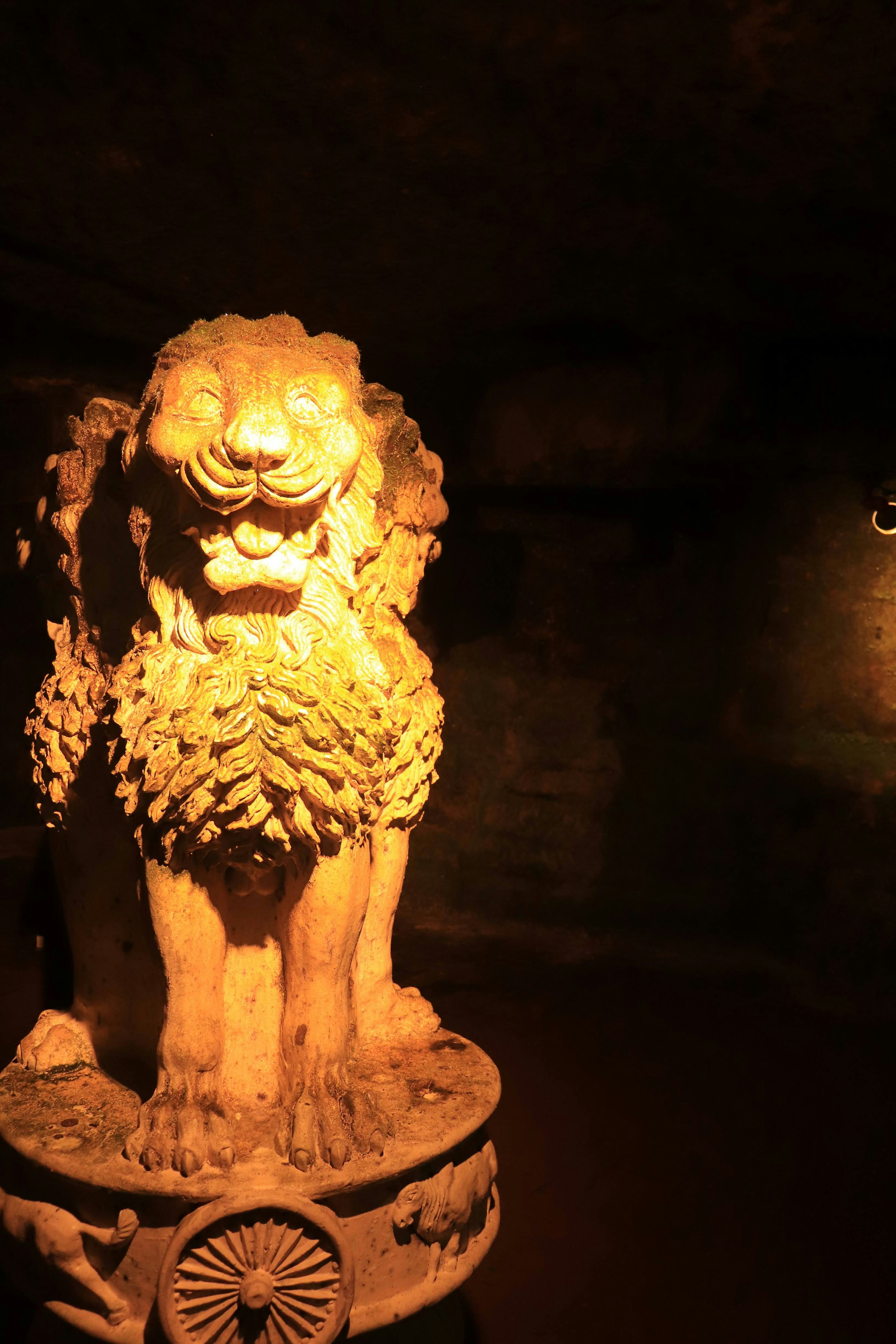 Sculpture de lion dans une grotte sombre avec un éclairage doux