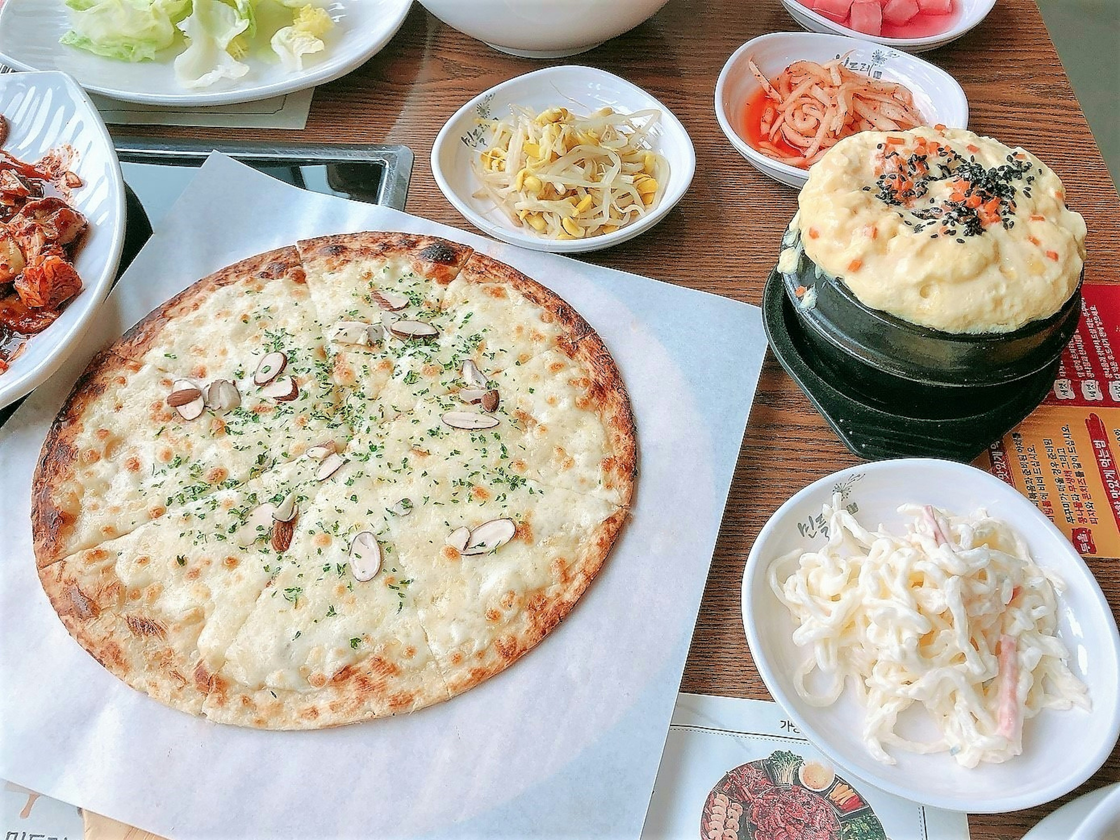 A table filled with various dishes including cheese pizza