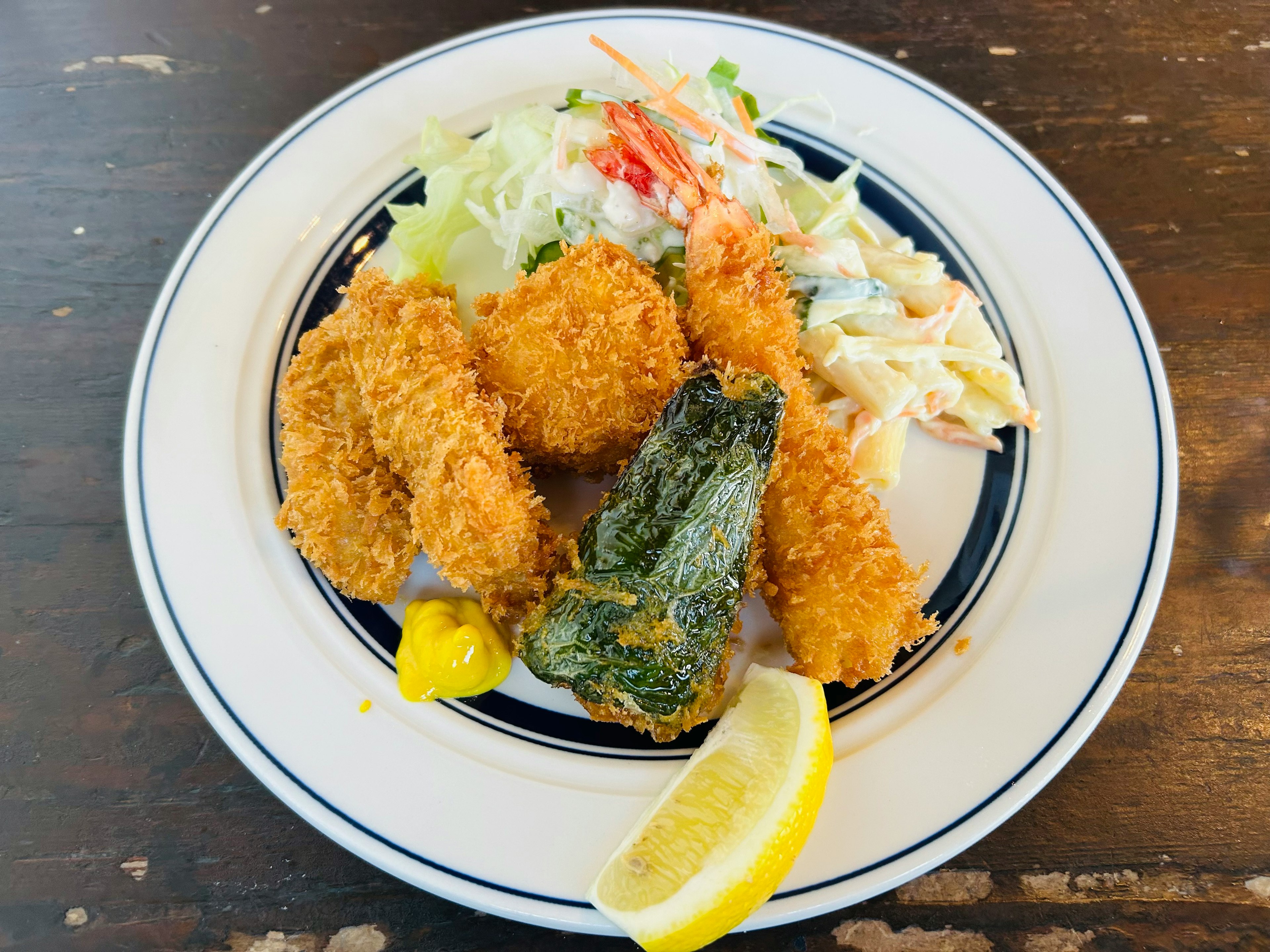 Plate of breaded fried oysters with lemon slice and coleslaw