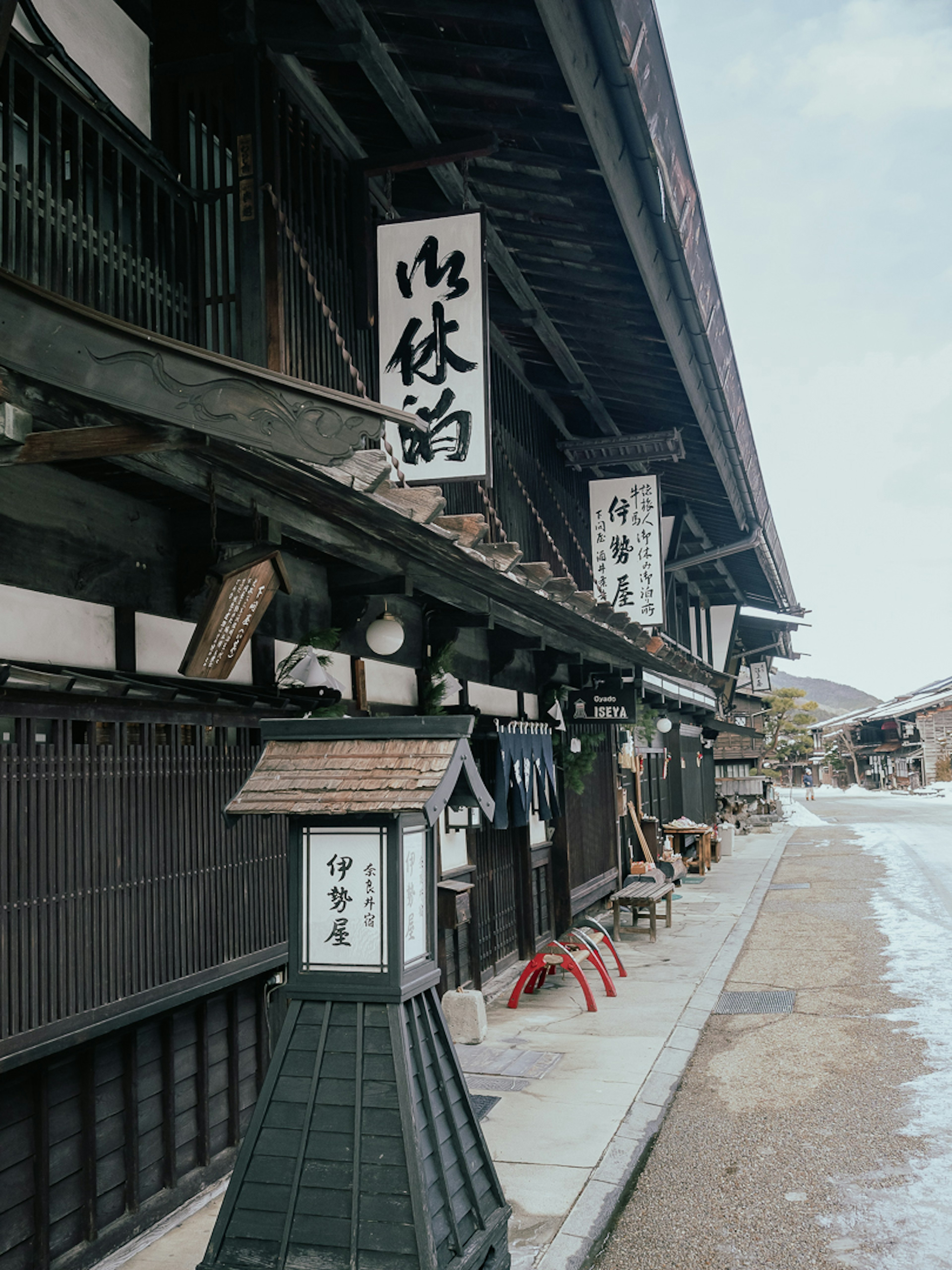 Pemandangan luar penginapan tradisional Jepang dengan papan nama dan arsitektur klasik