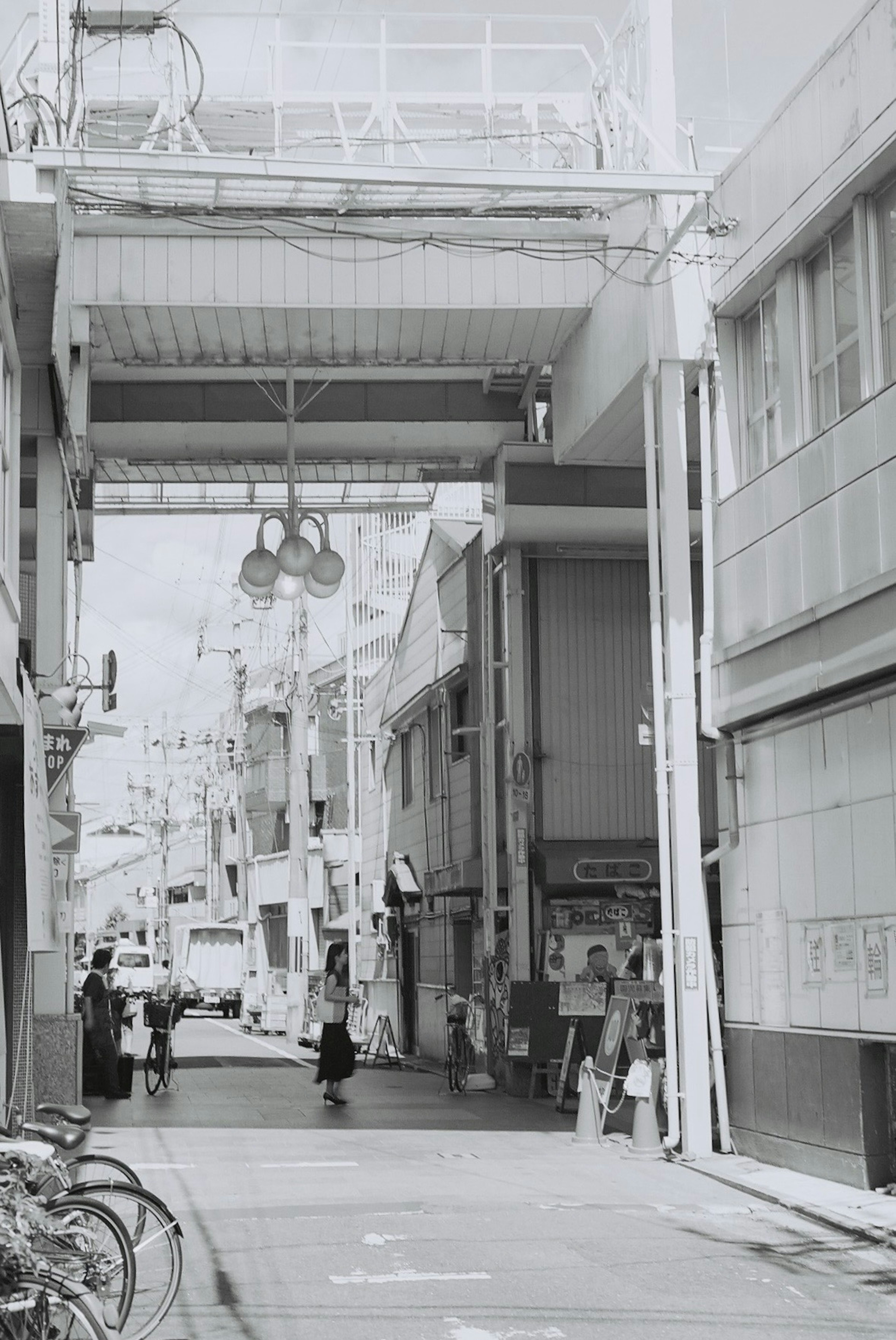 Scène urbaine en noir et blanc avec rue étroite et piétons