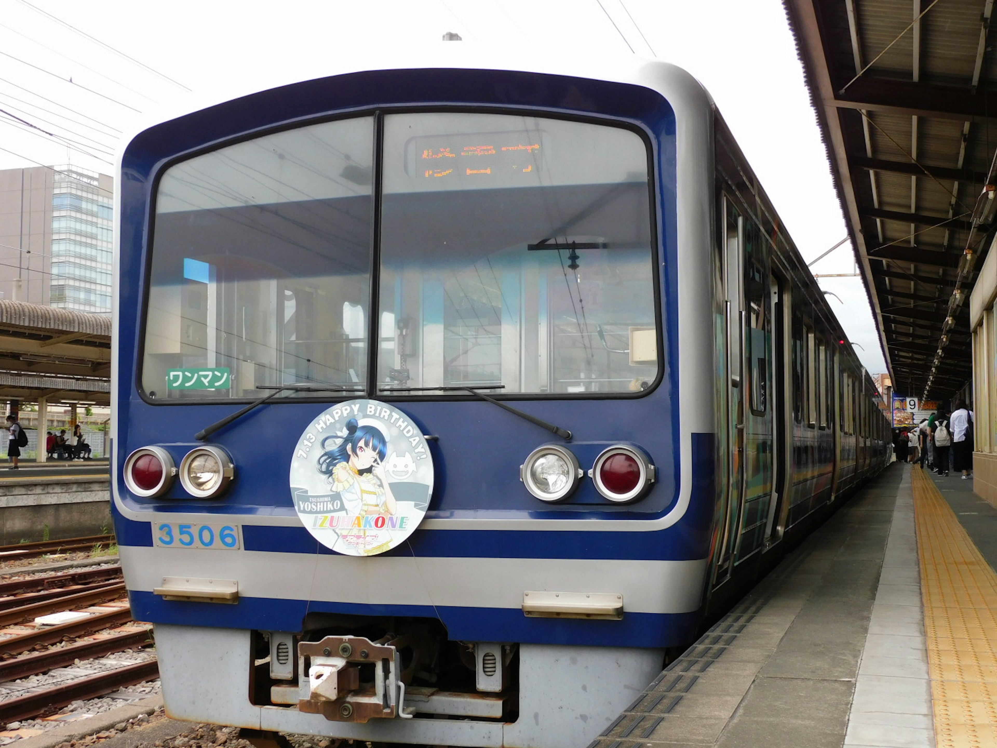 Tren azul detenido en una estación con decoración especial