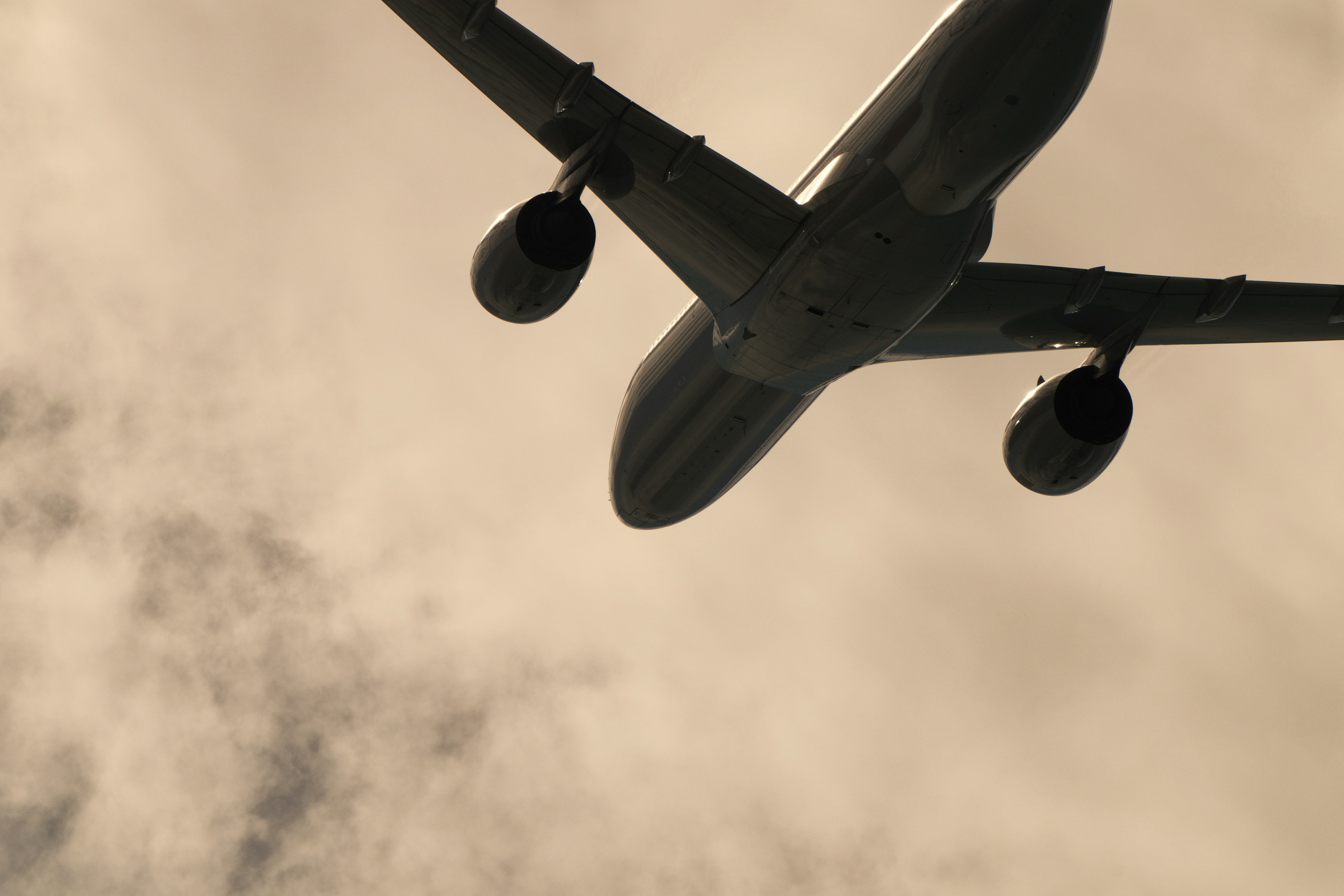 Underneath view of an airplane flying above the clouds