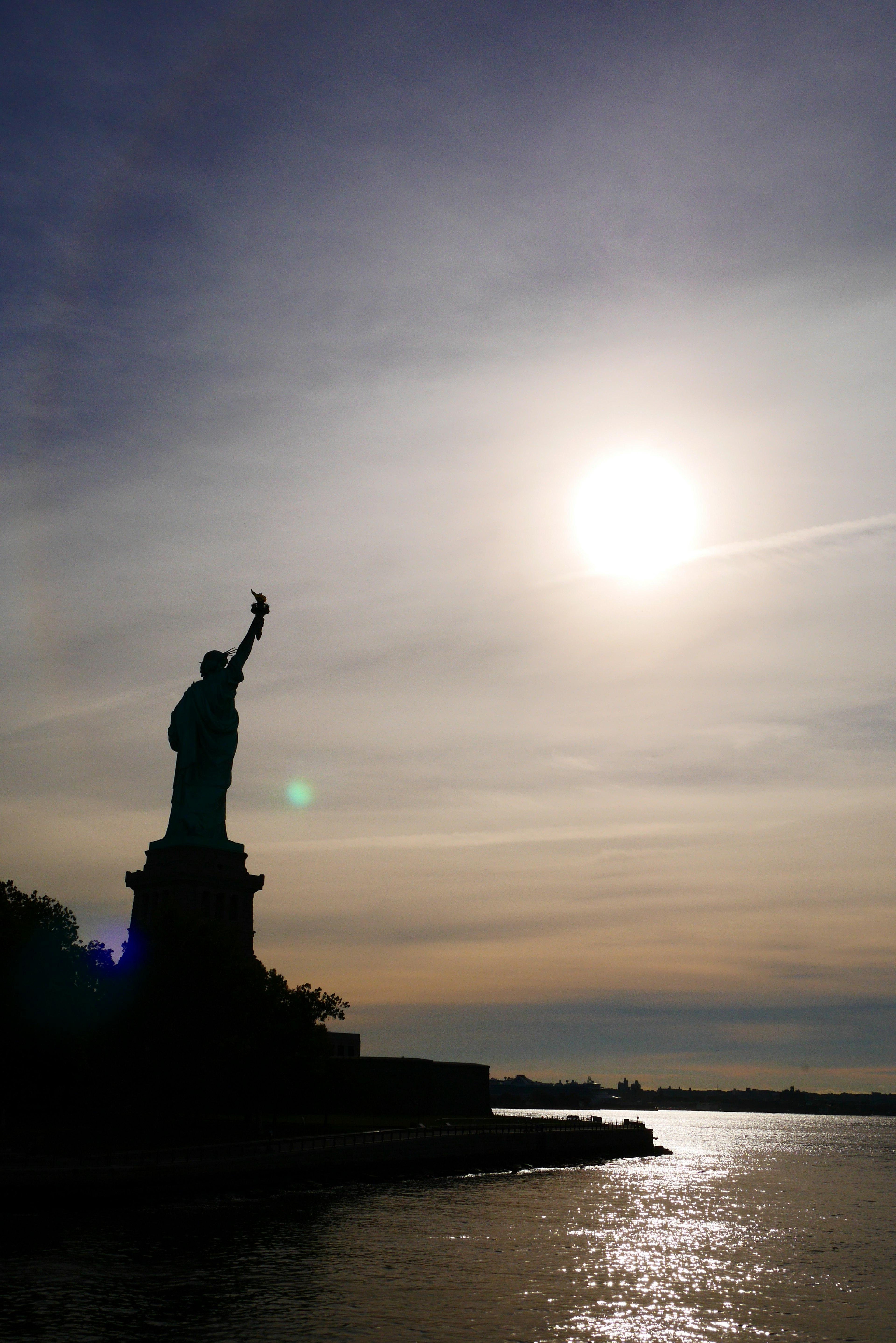 Silhouette of the Statue of Liberty against a sunset