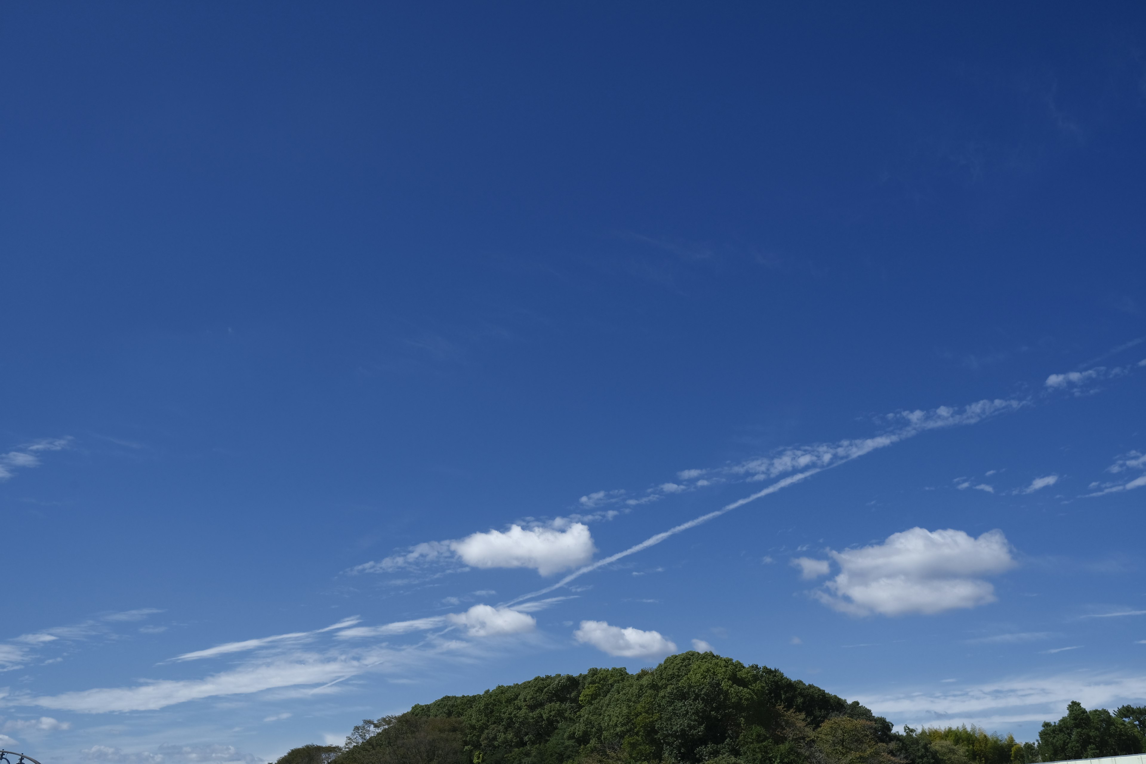 Expansive blue sky with scattered white clouds