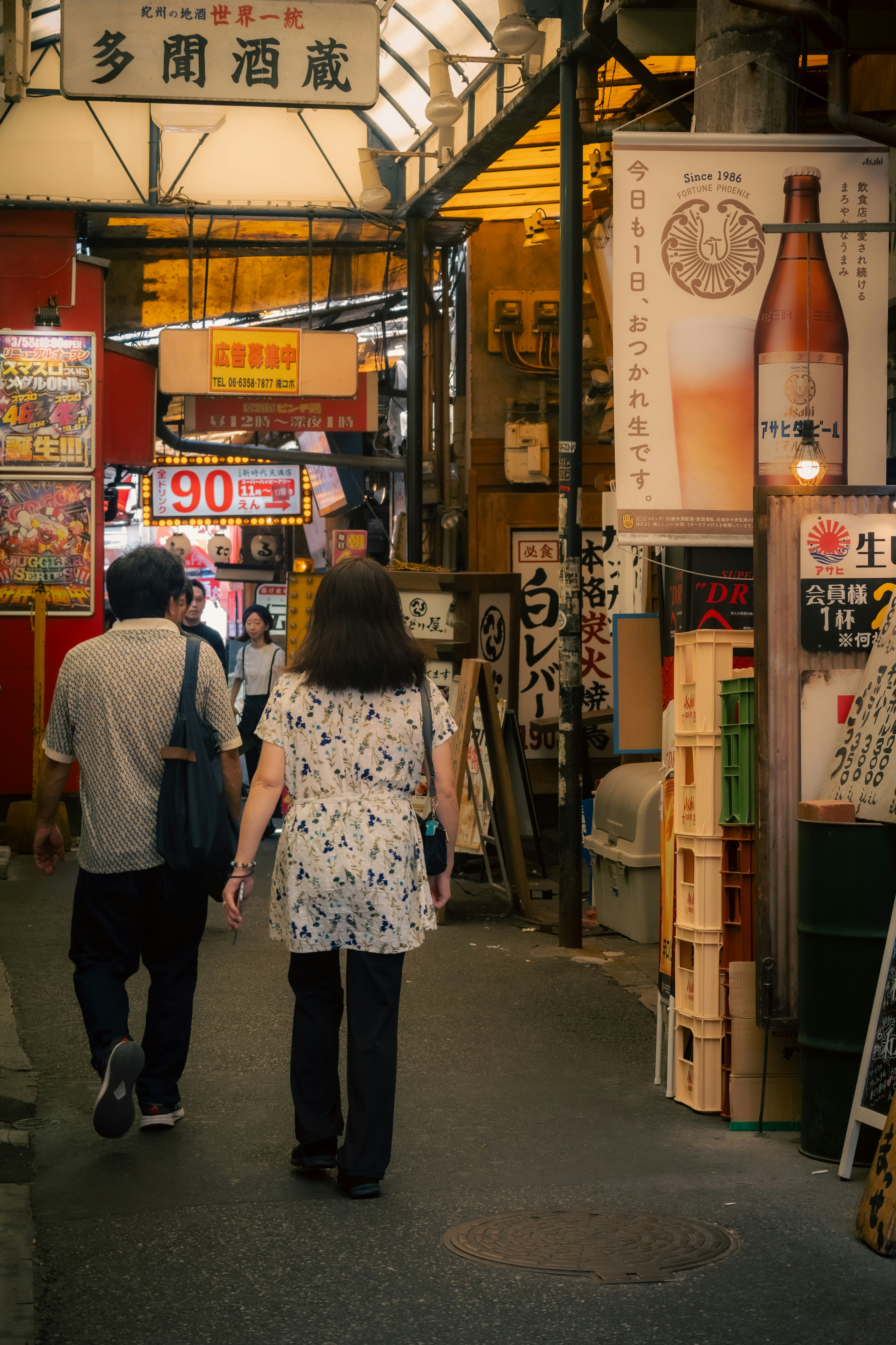 賑やかな商店街を歩く人々と酒の看板