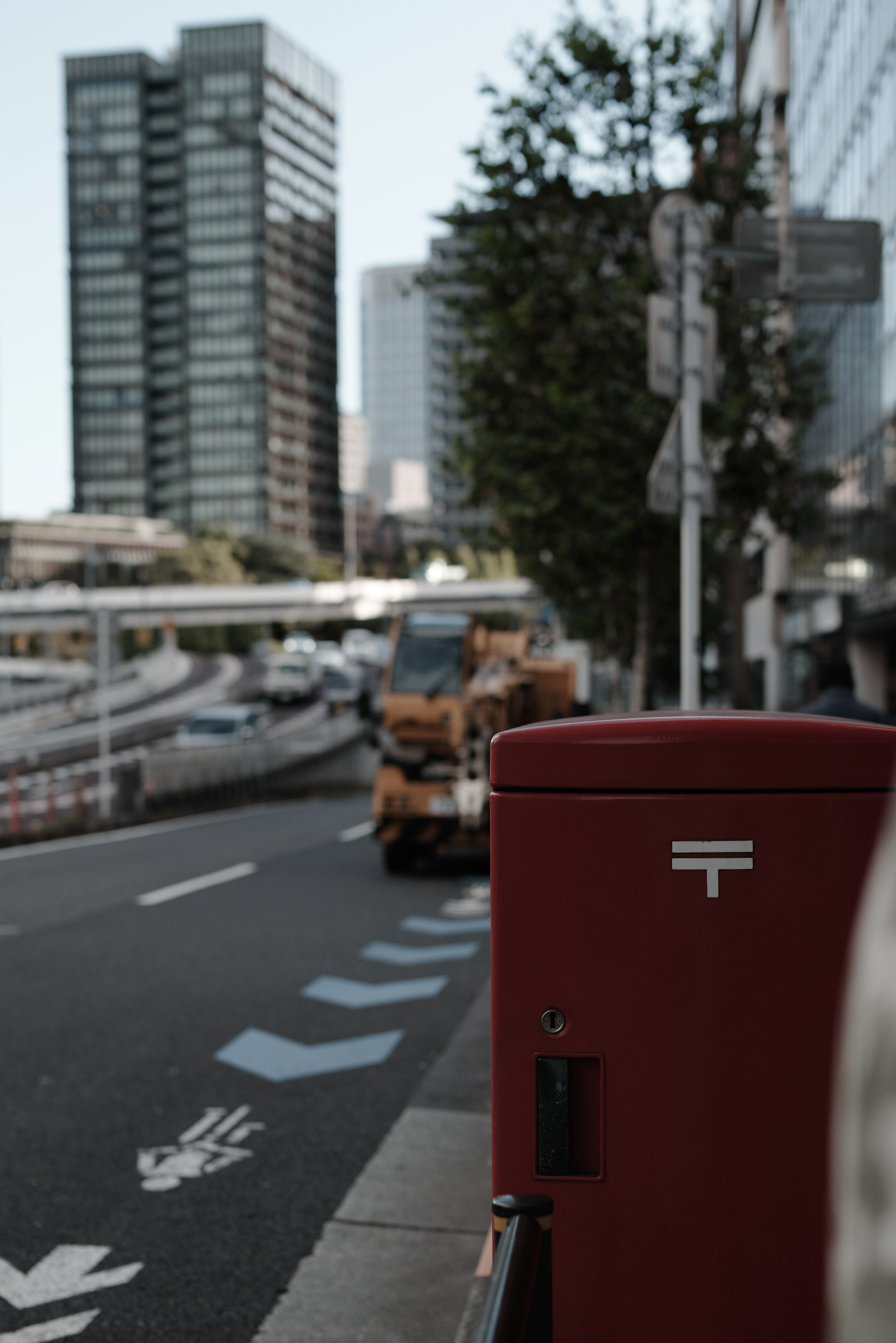 Red post box with urban scenery and buildings in background