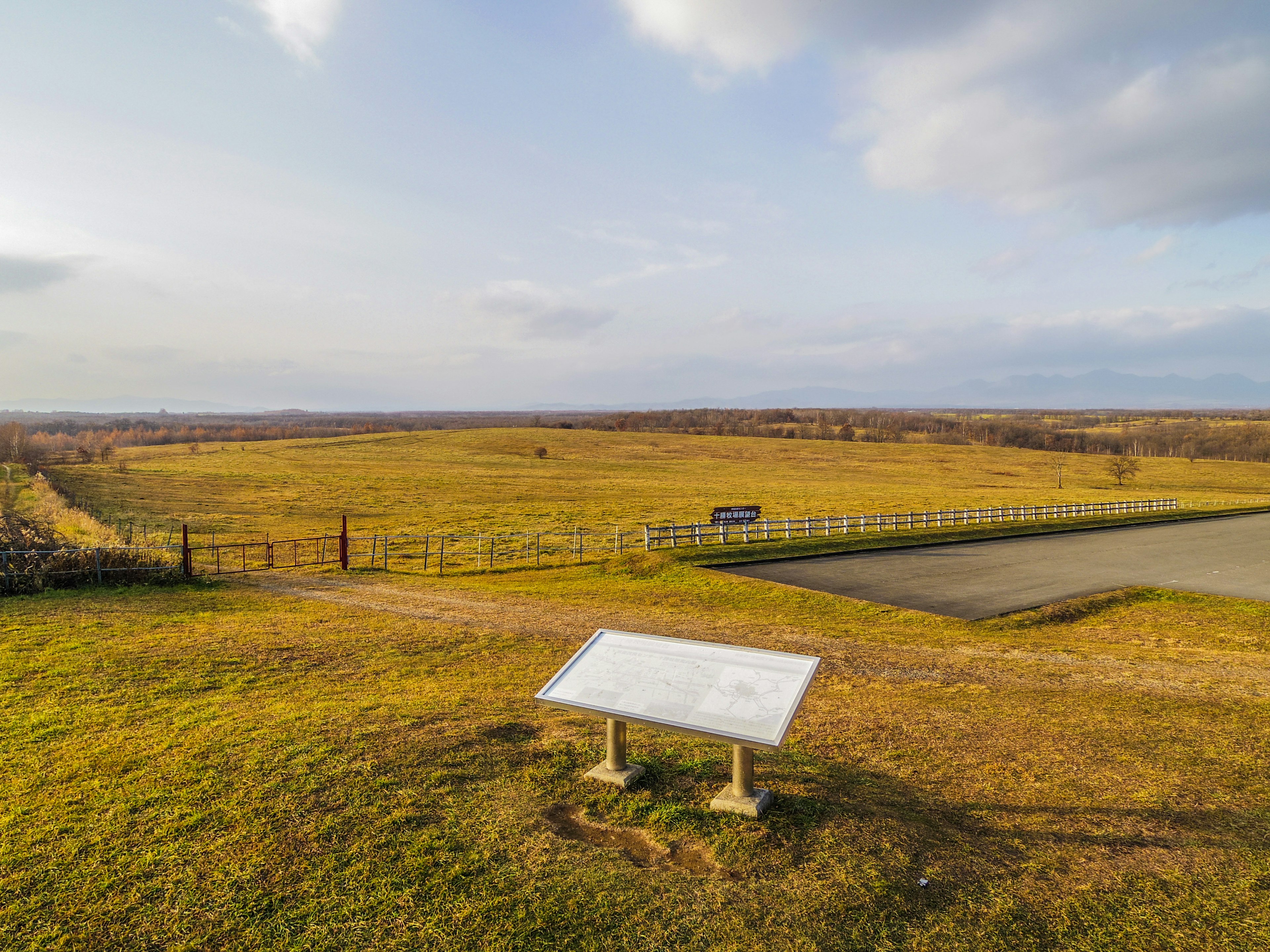 Vast grassy landscape with an informational sign