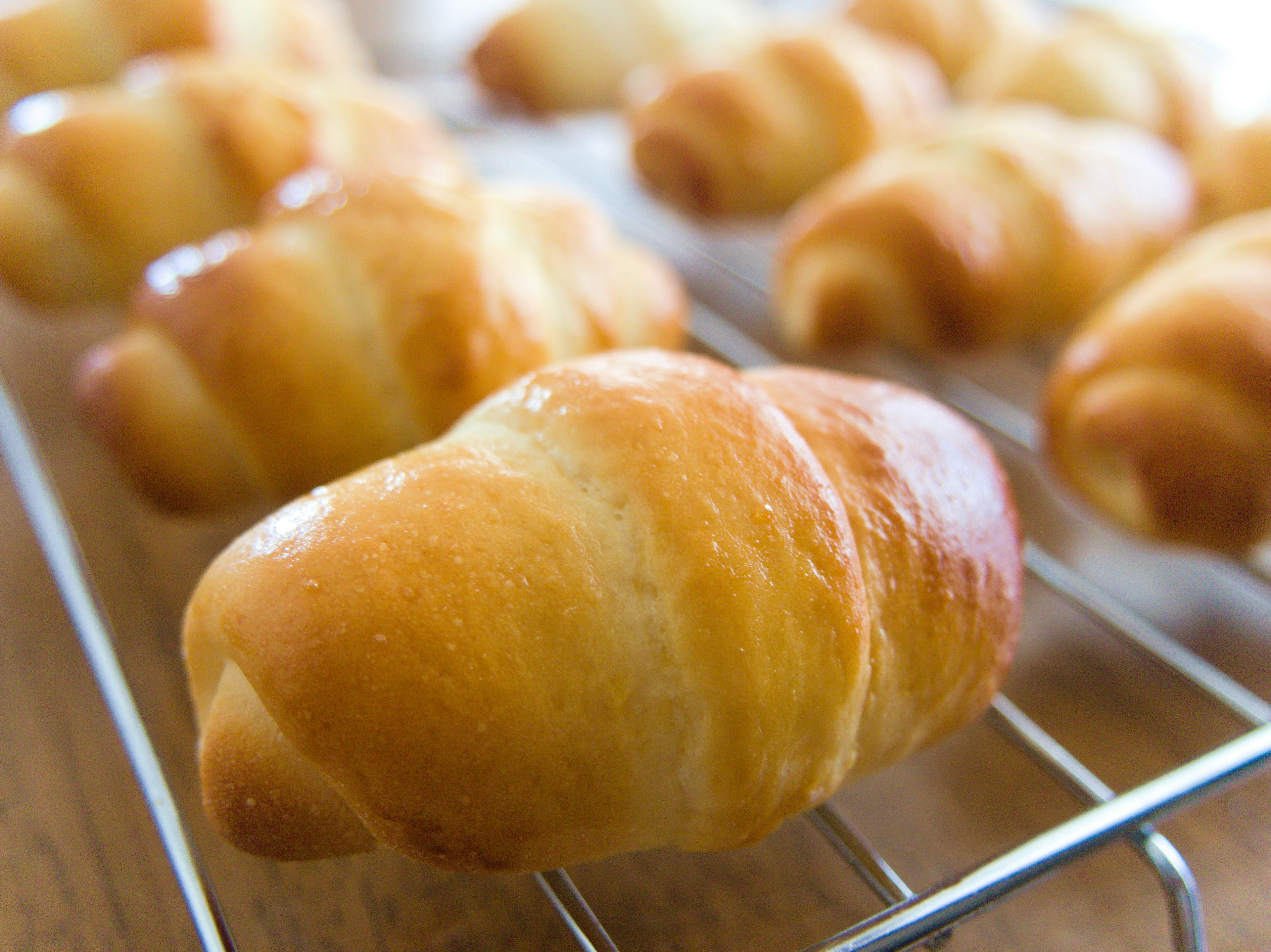 Croissants recién horneados en una rejilla de enfriamiento