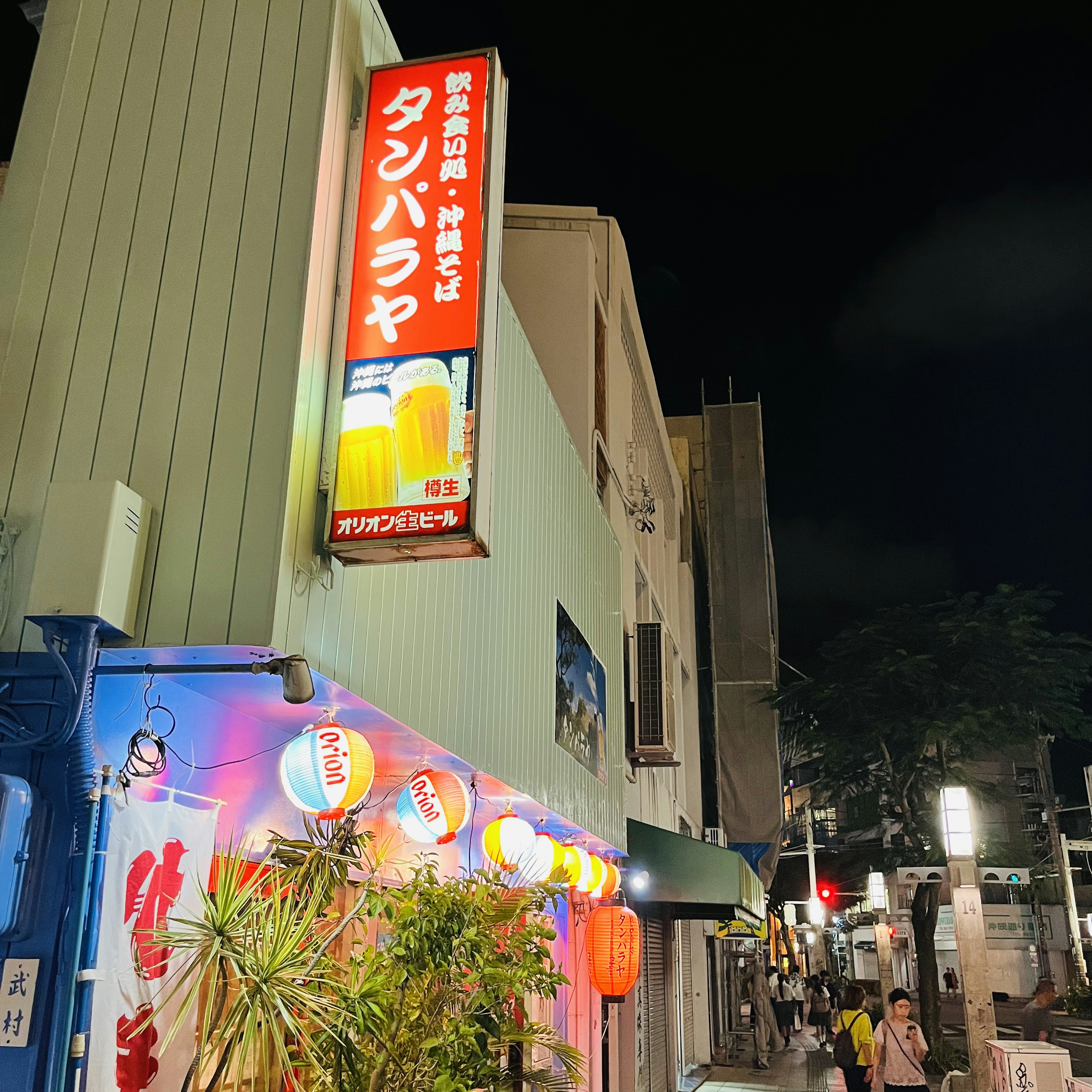 Cartel de izakaya y faroles en una esquina de la calle de noche