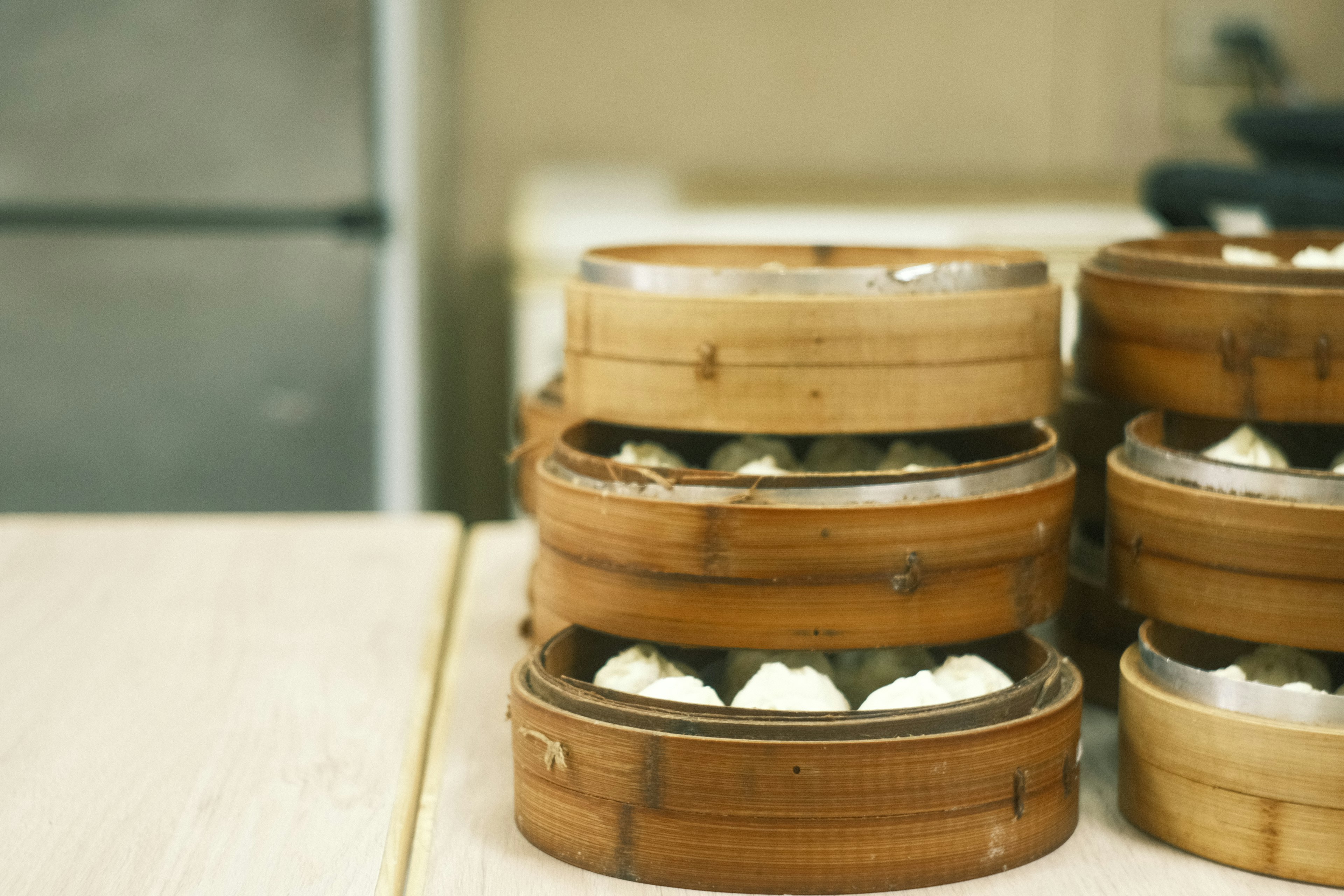 Vaporeras de bambú llenas de dumplings sobre una mesa de madera