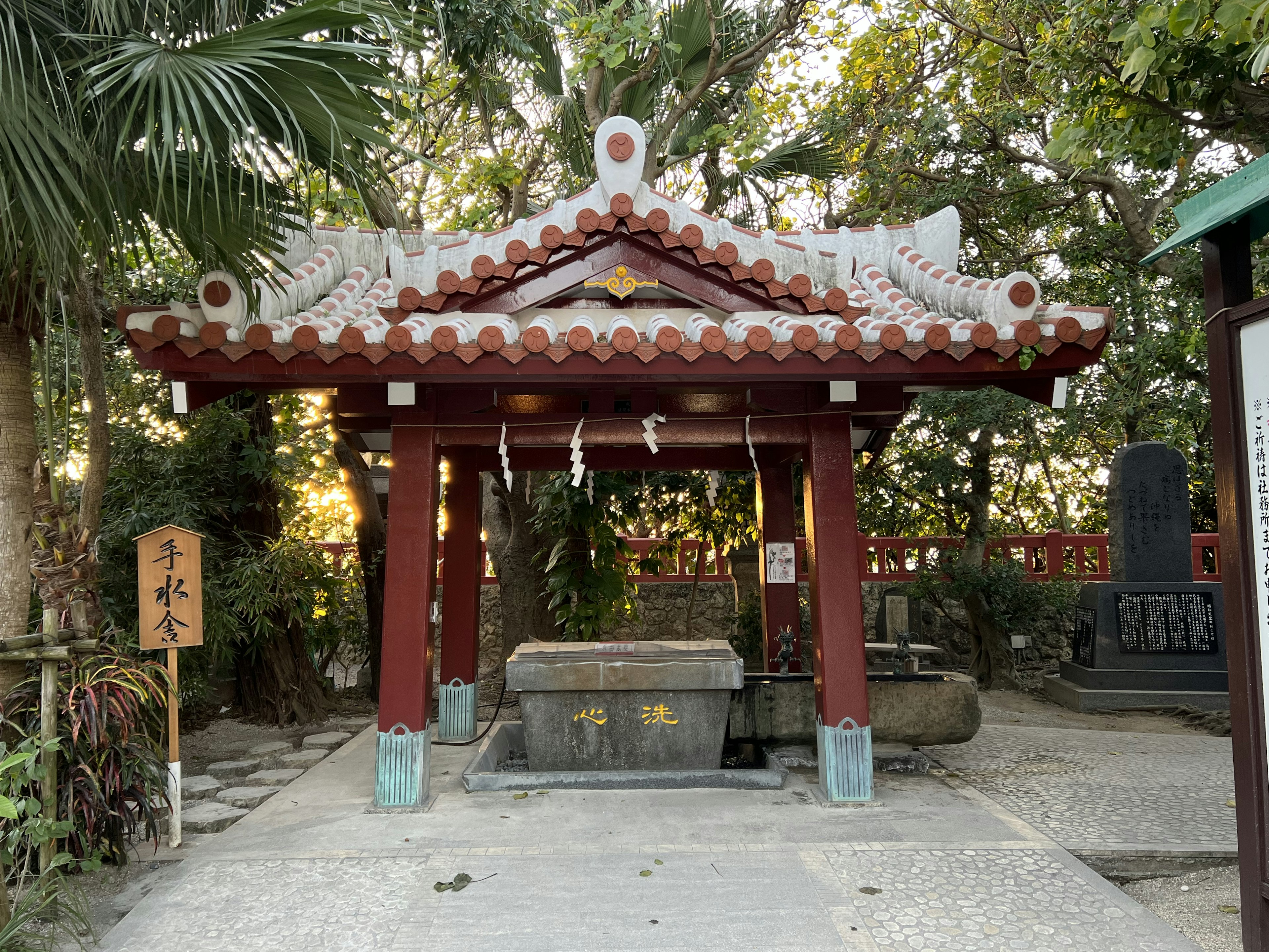 赤い屋根の神社の建物と周囲の緑の植物