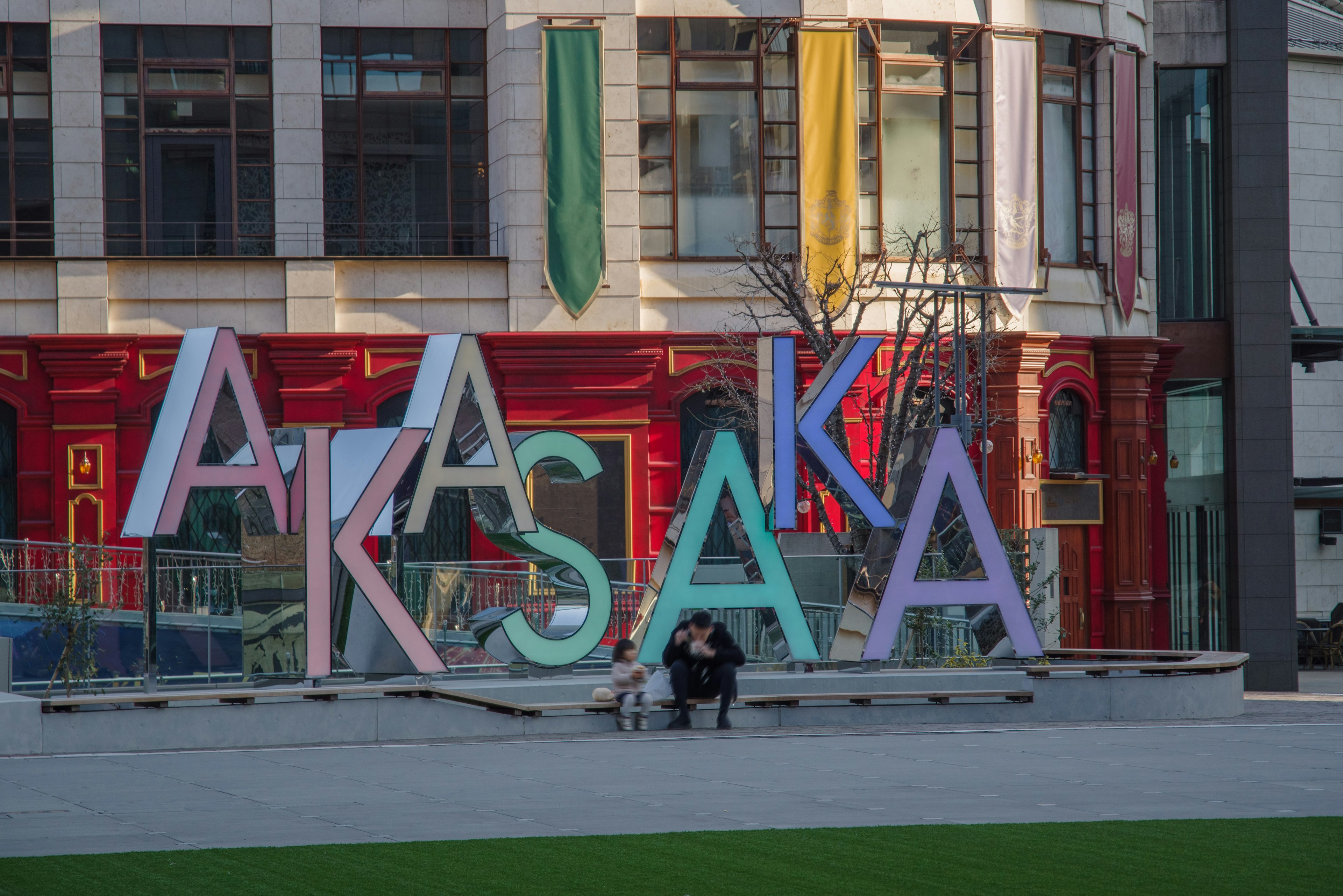 Karya seni huruf berwarna di Akasaka dengan latar belakang taman