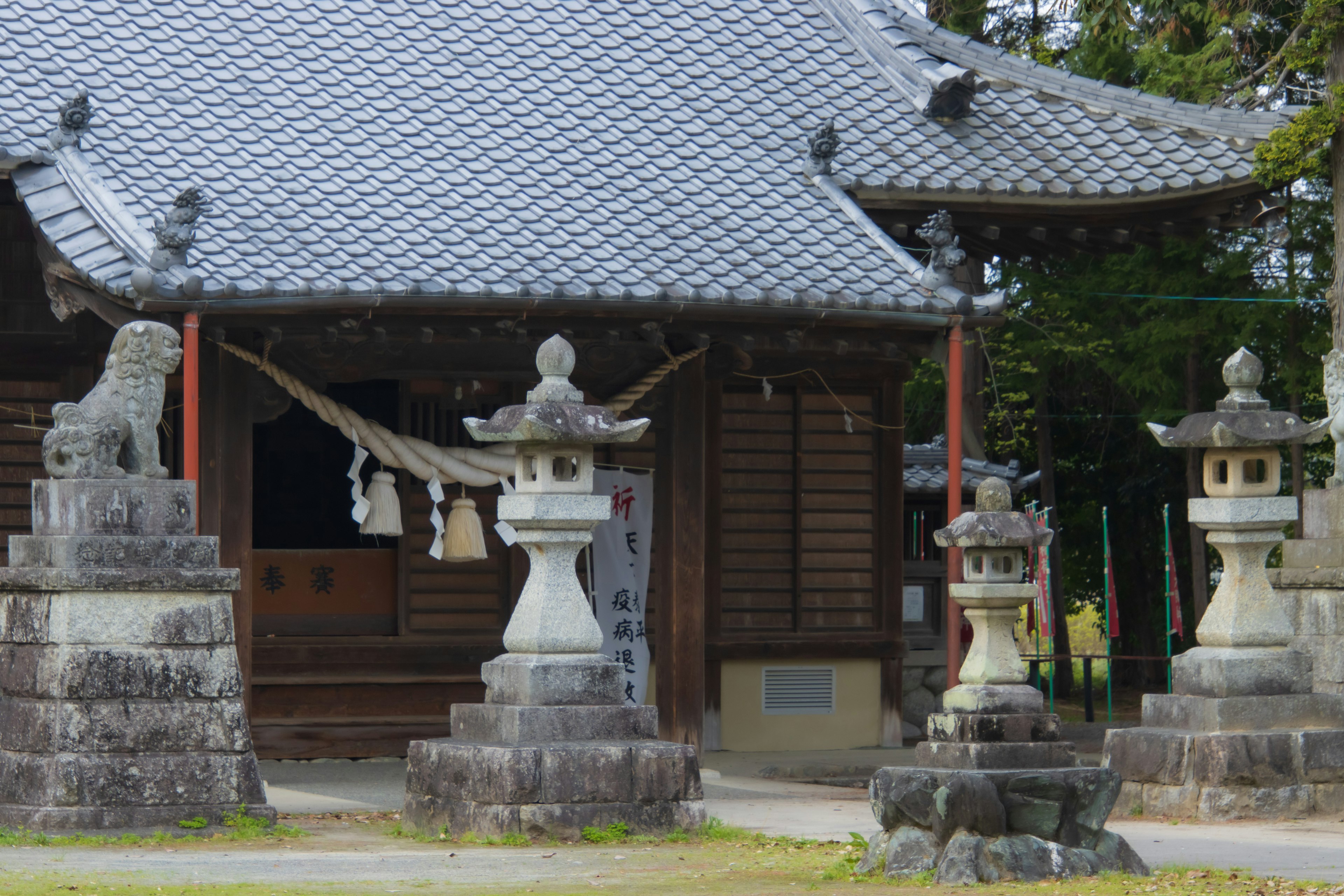 Entrée d'un temple japonais traditionnel avec lanternes en pierre et statues de komainu