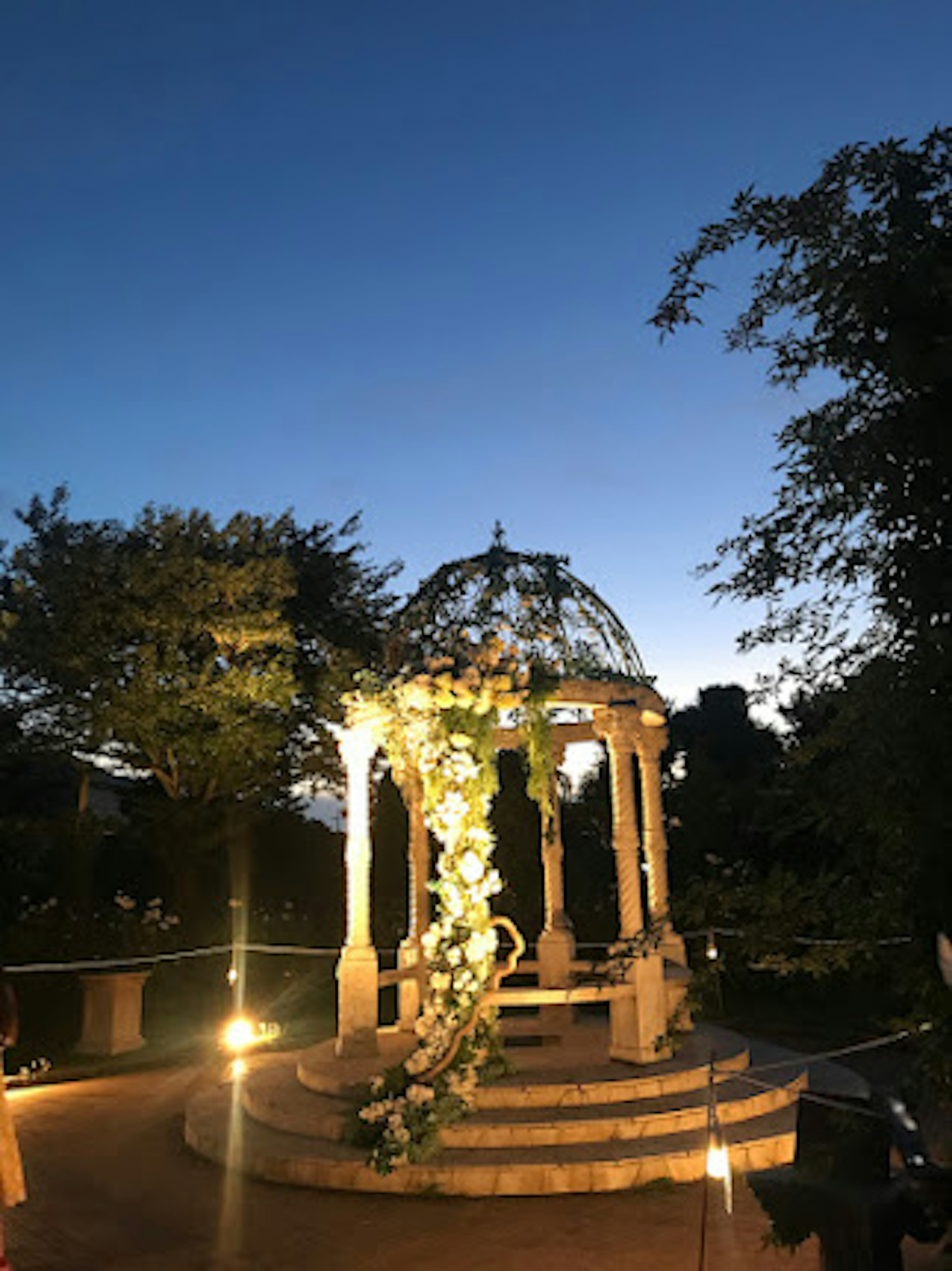 A beautiful gazebo under the night sky adorned with floral decorations