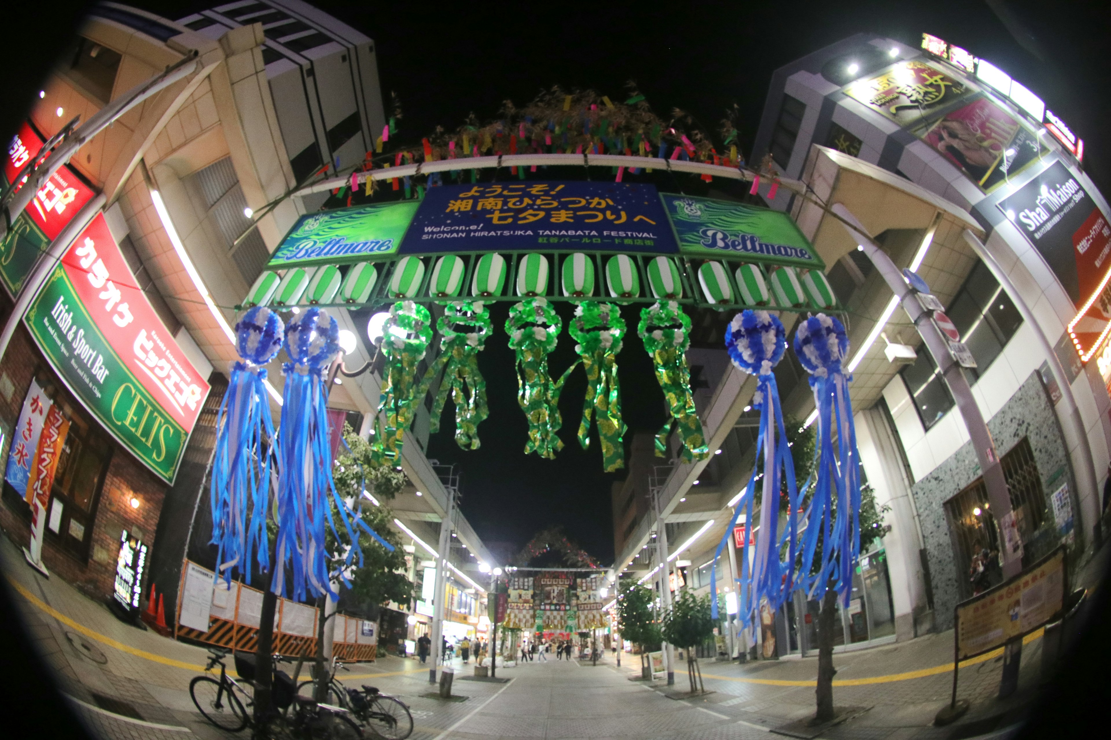 夜の街に飾られた青と緑のリボンと装飾が見える