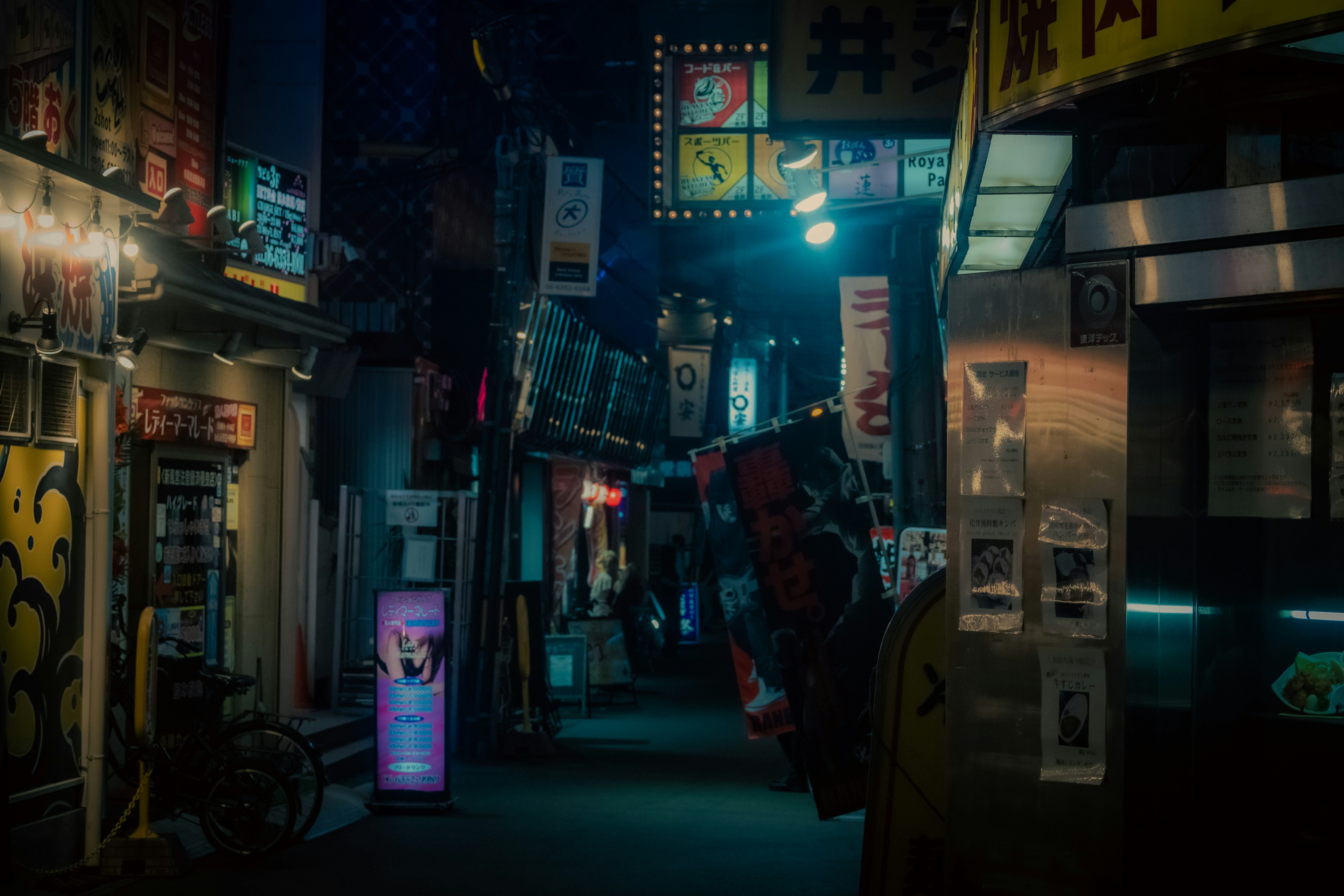 Narrow Japanese alley illuminated by neon signs at night