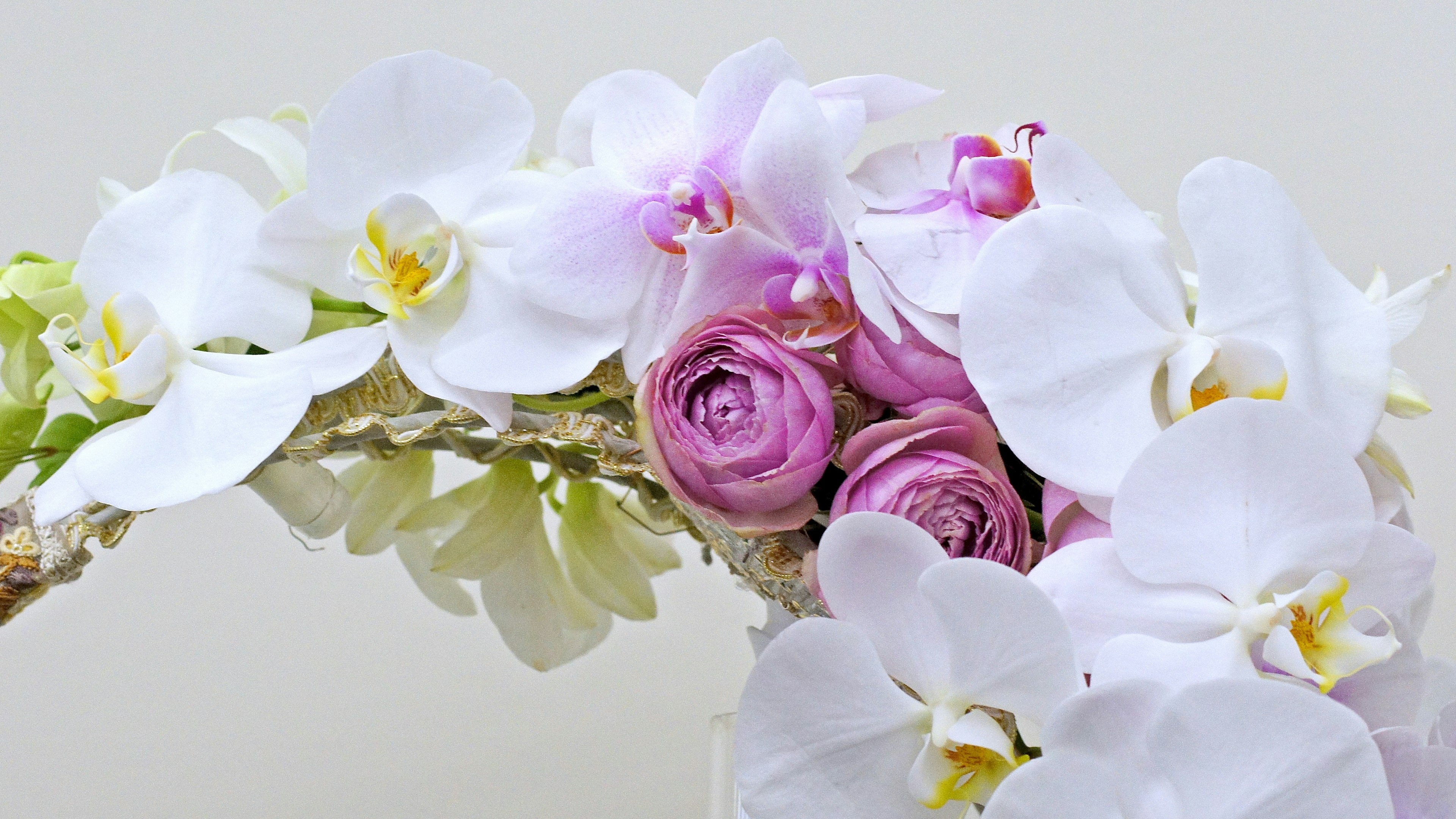 Composizione di orchidee bianche e rose rosa