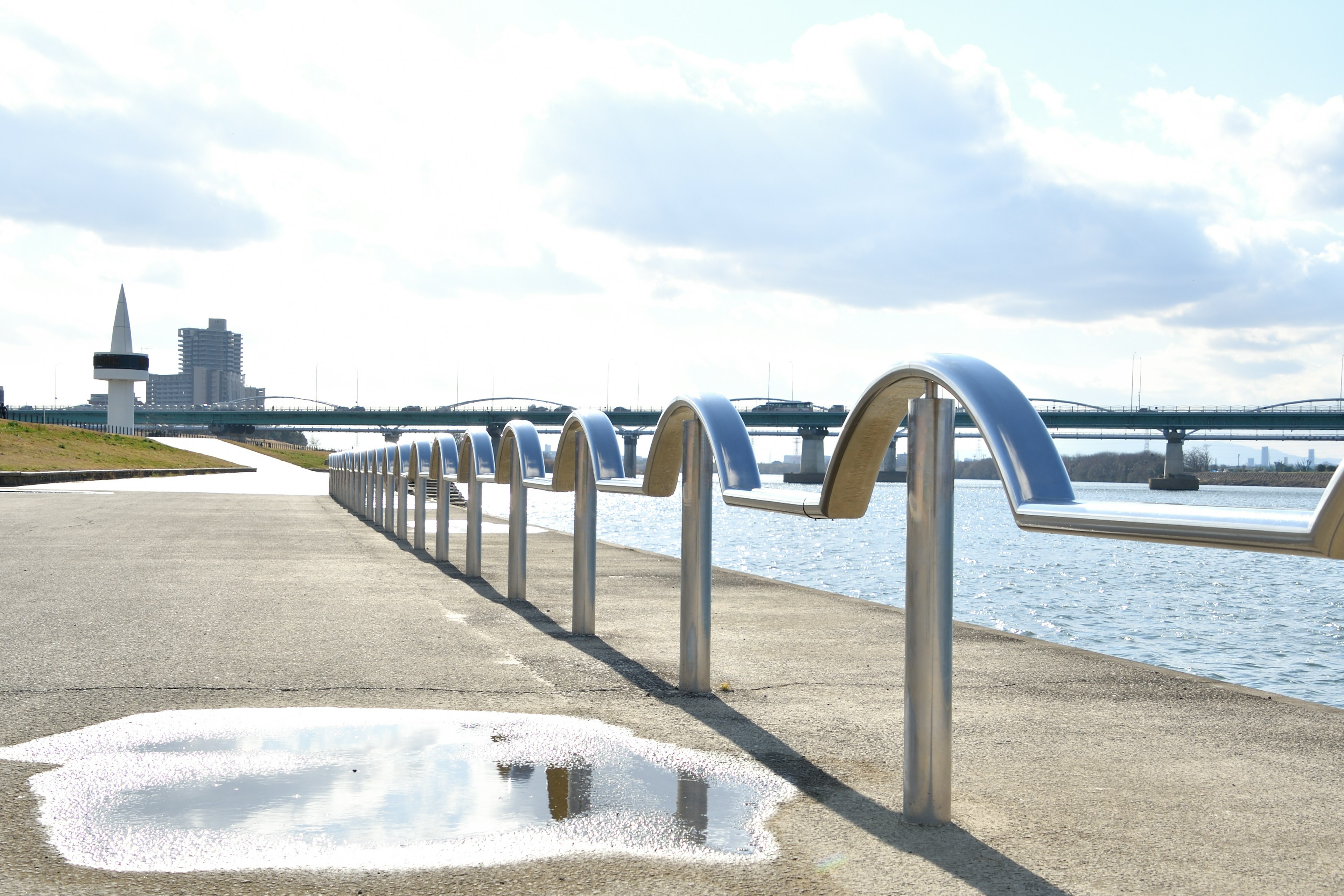 Waterfront railing with a blue sky and reflections