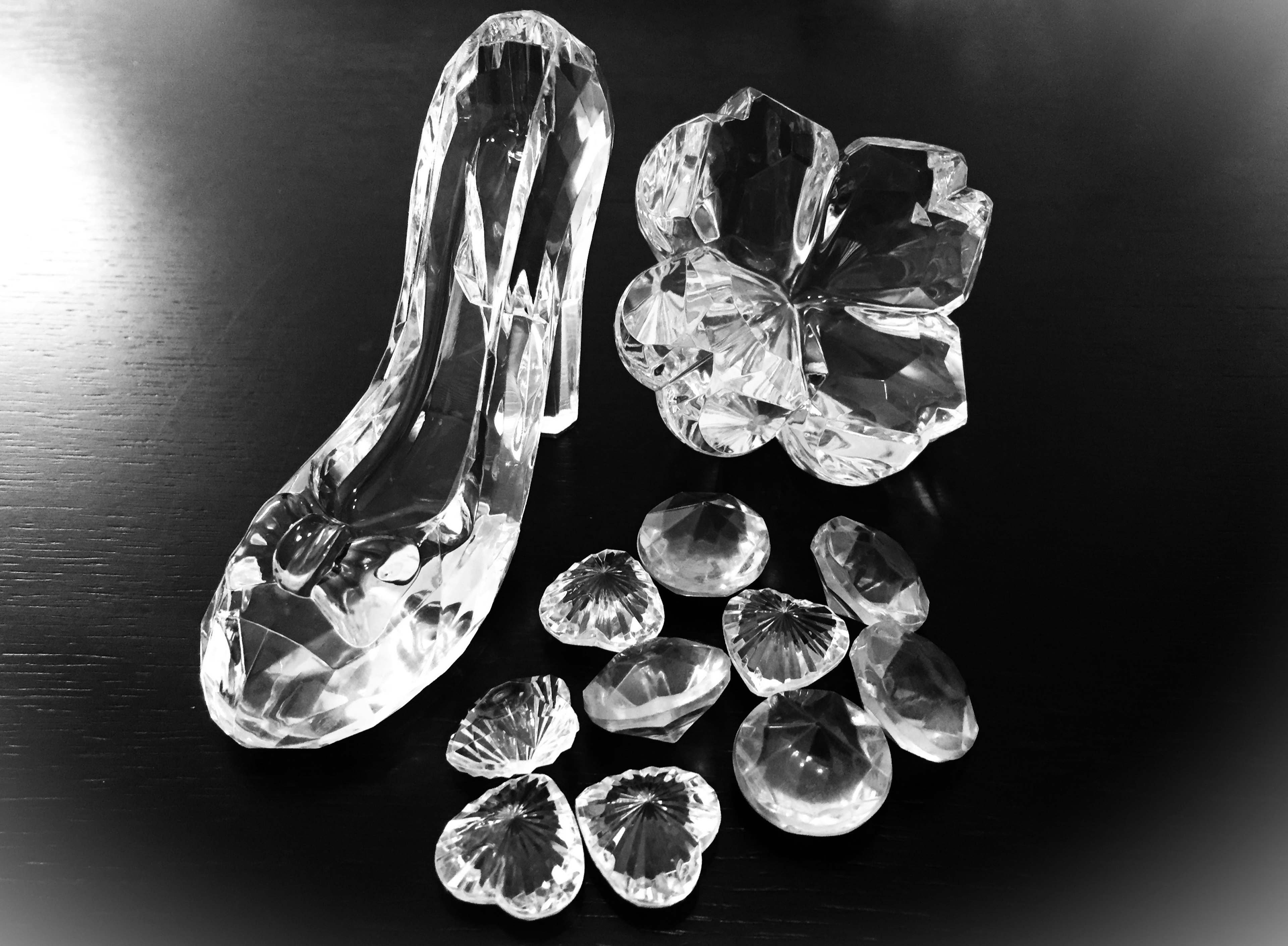 A transparent crystal high heel and flower objects are displayed