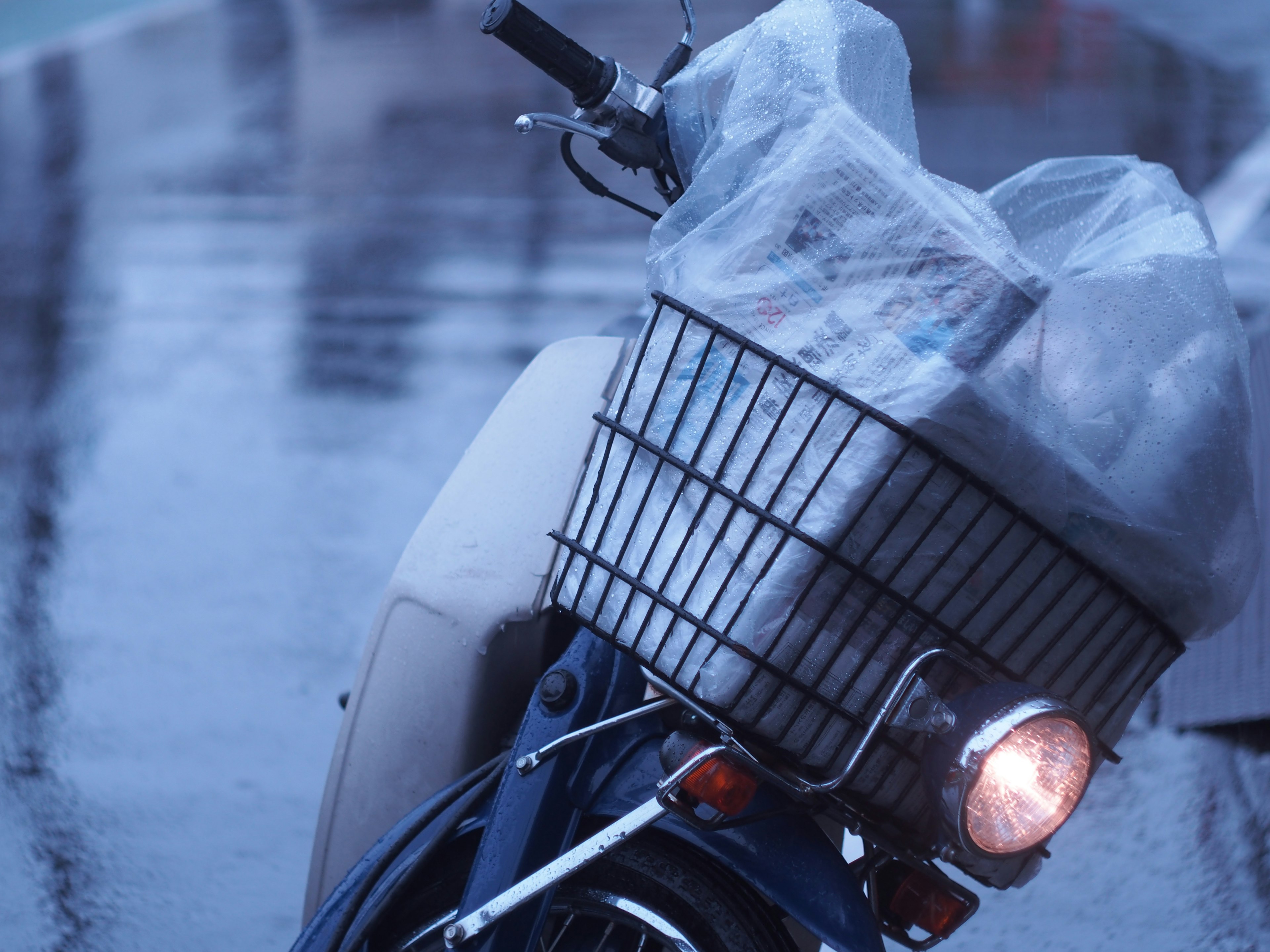 雨の中の自転車と透明なカバーがかかったバスケット