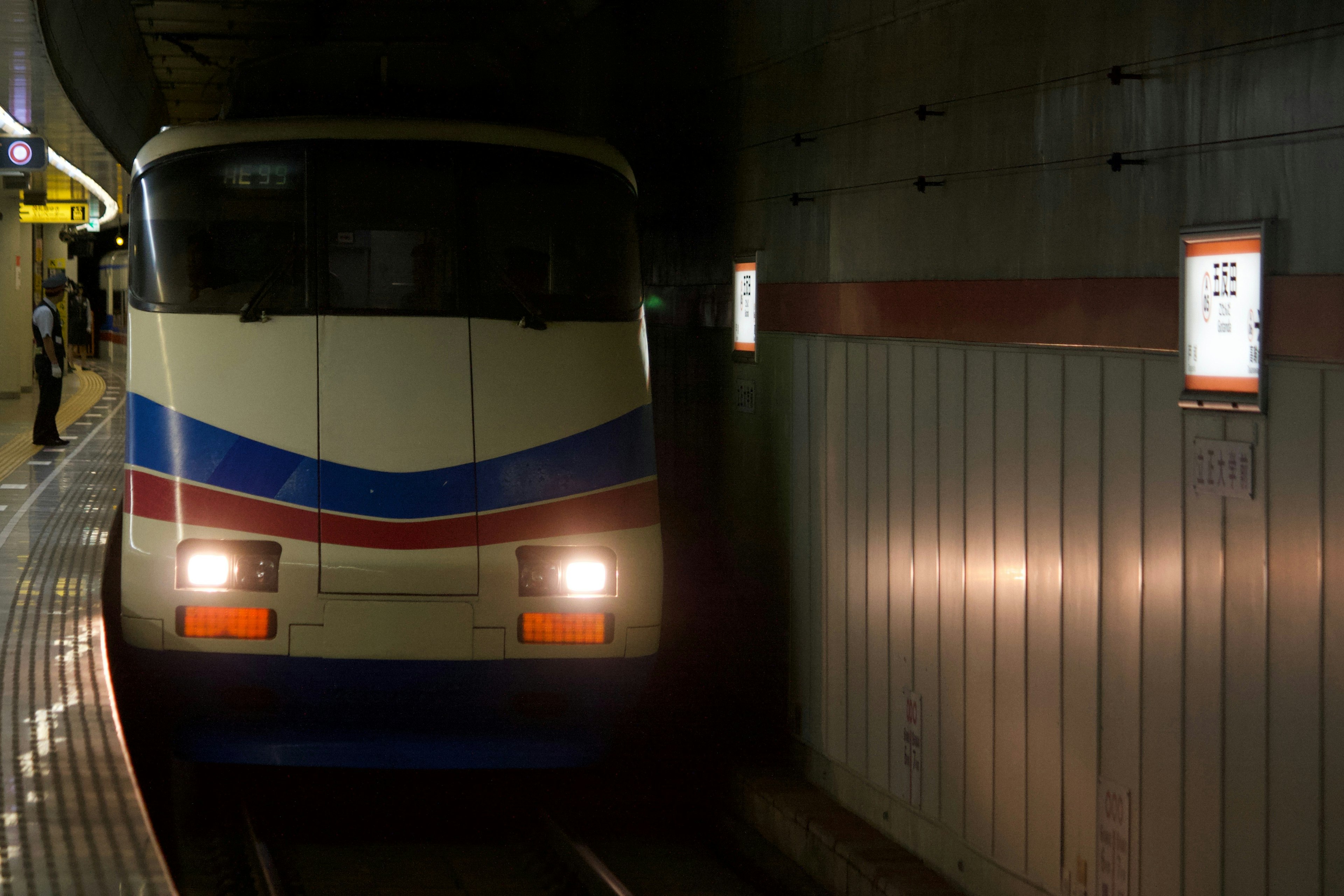 Train arrivant à la station de métro avec des rayures bleues et blanches