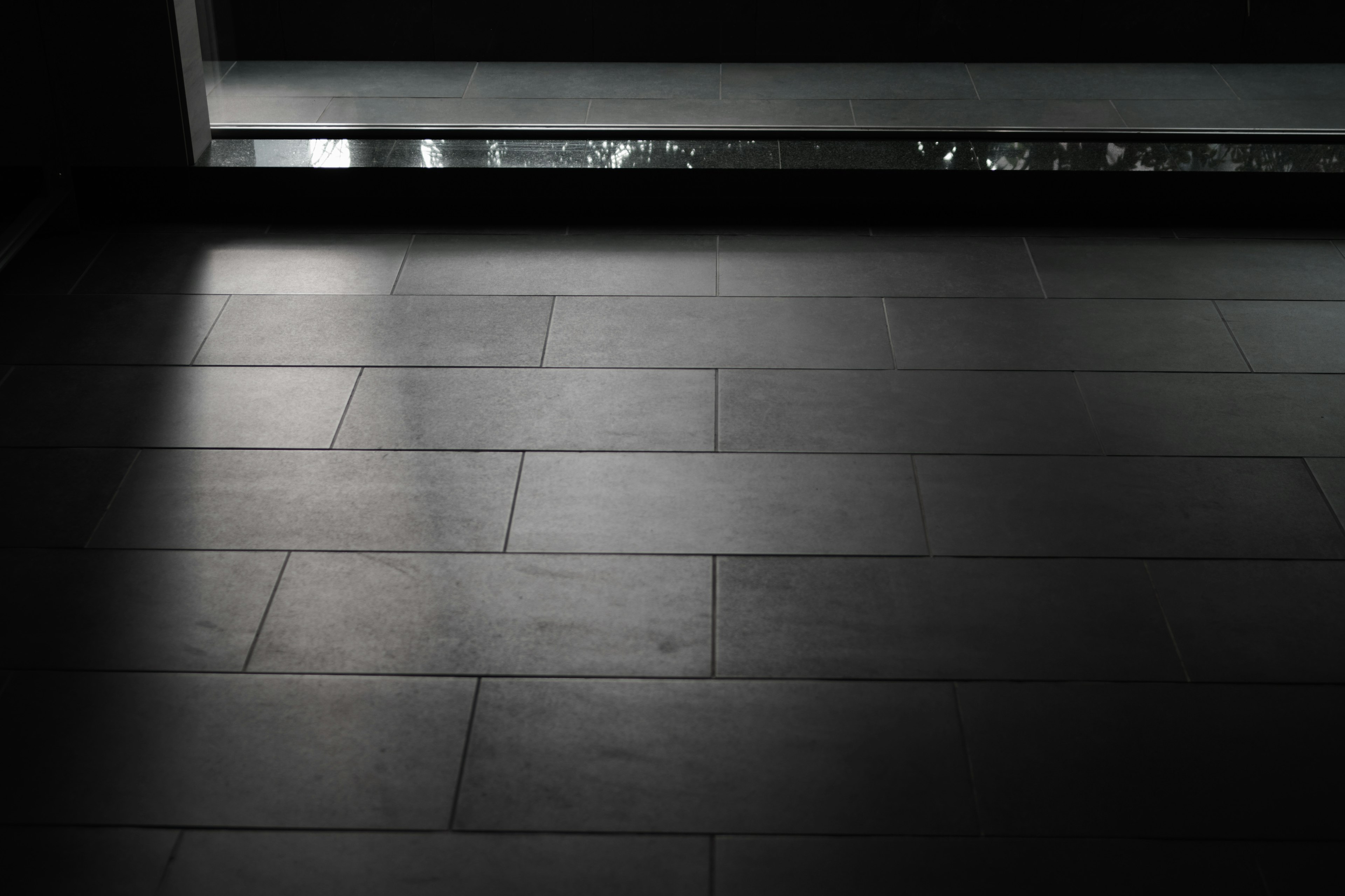 Interior view featuring dark tiled floor and light from a window