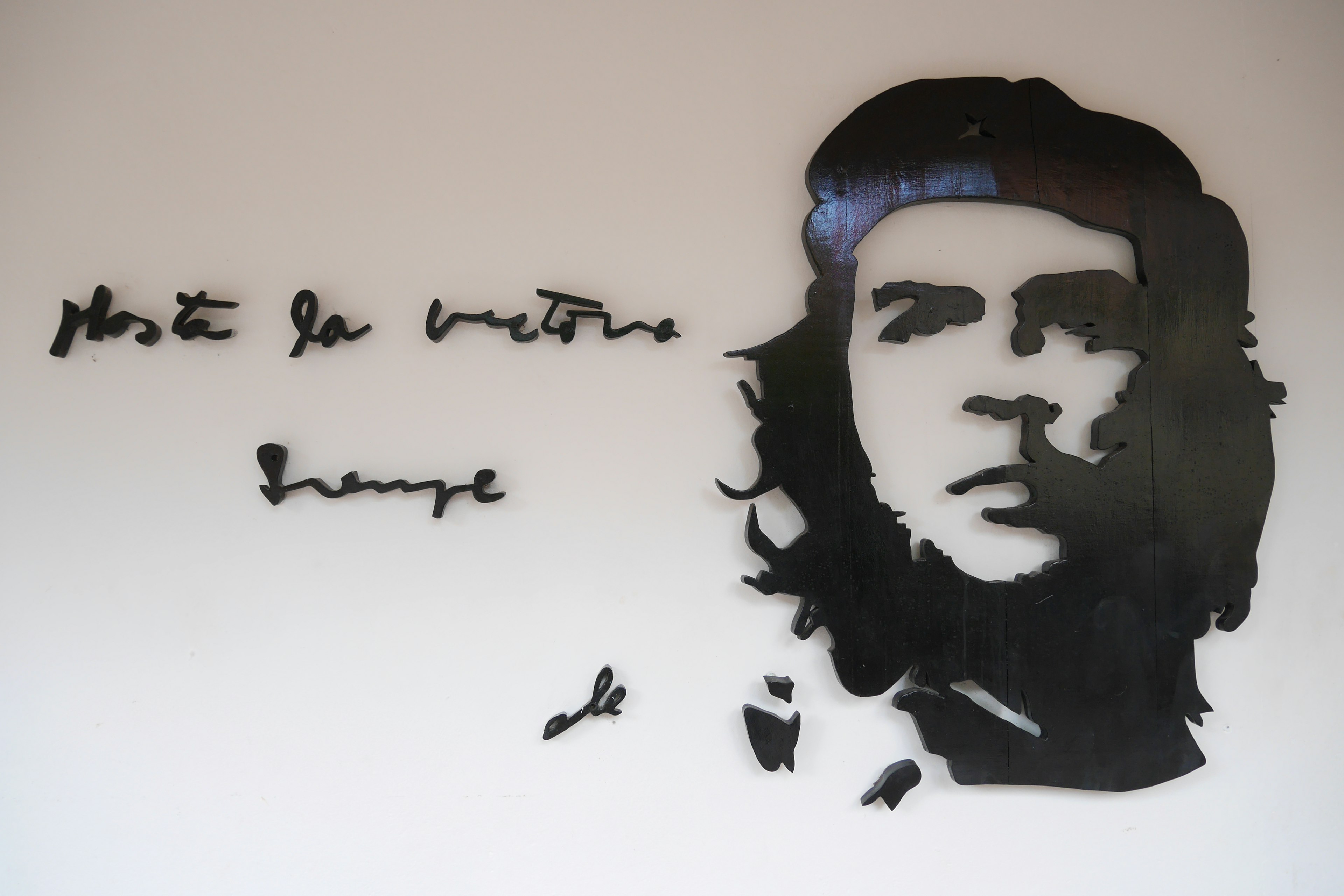 Silhouette of Che Guevara on a wall with Spanish text