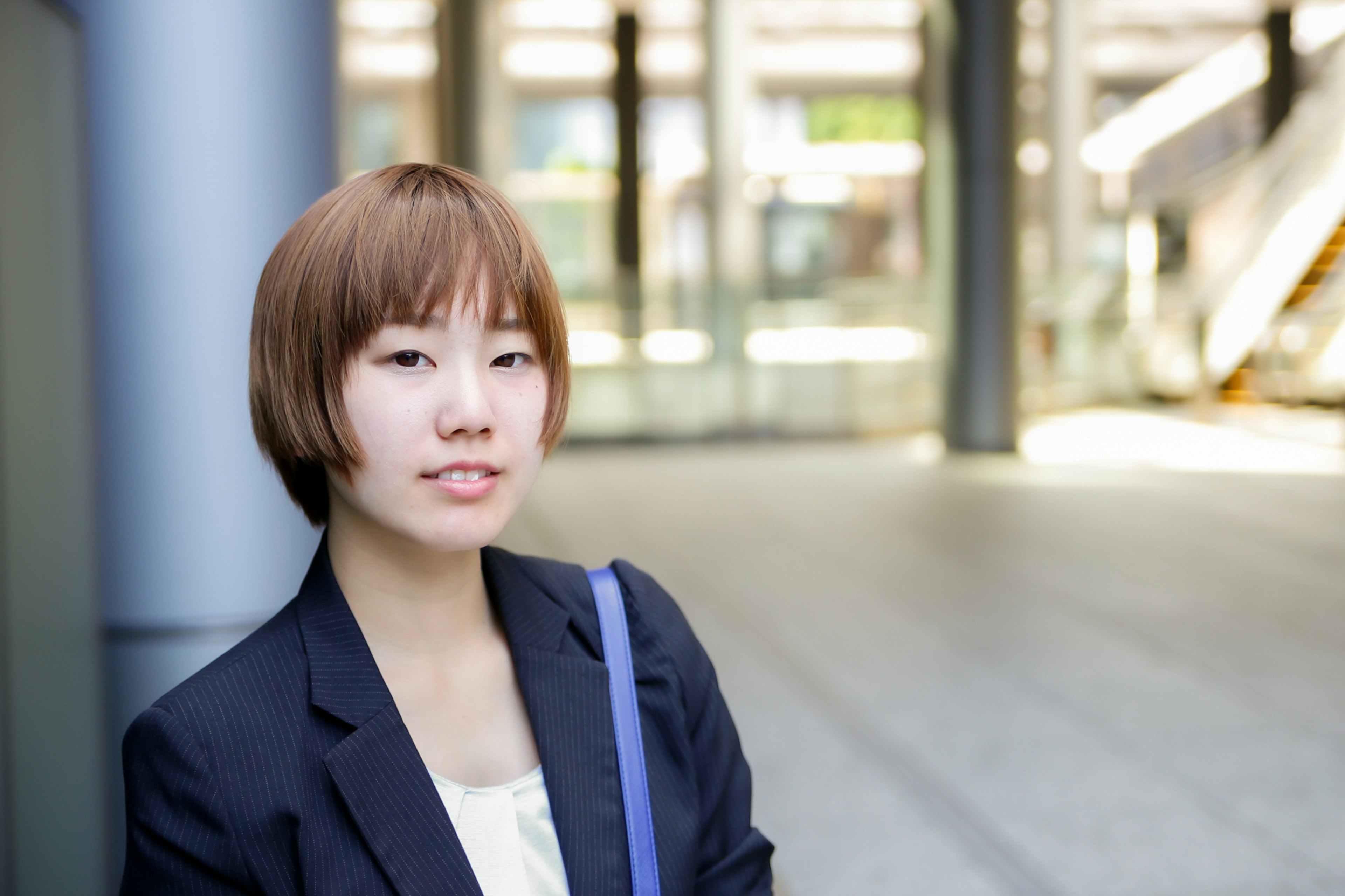 Young woman in a suit with a business setting background