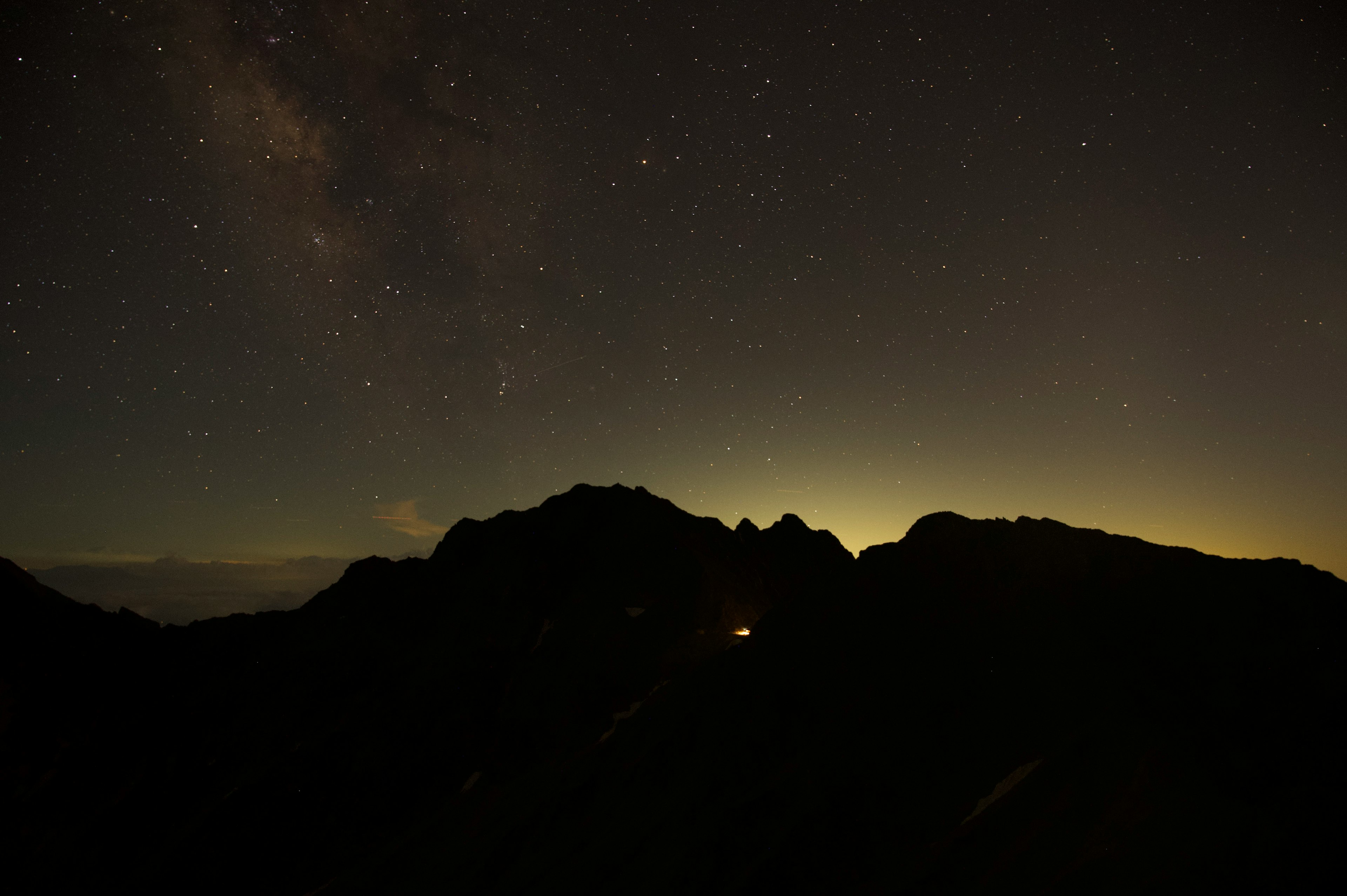 星空と山のシルエットが映る夜の風景