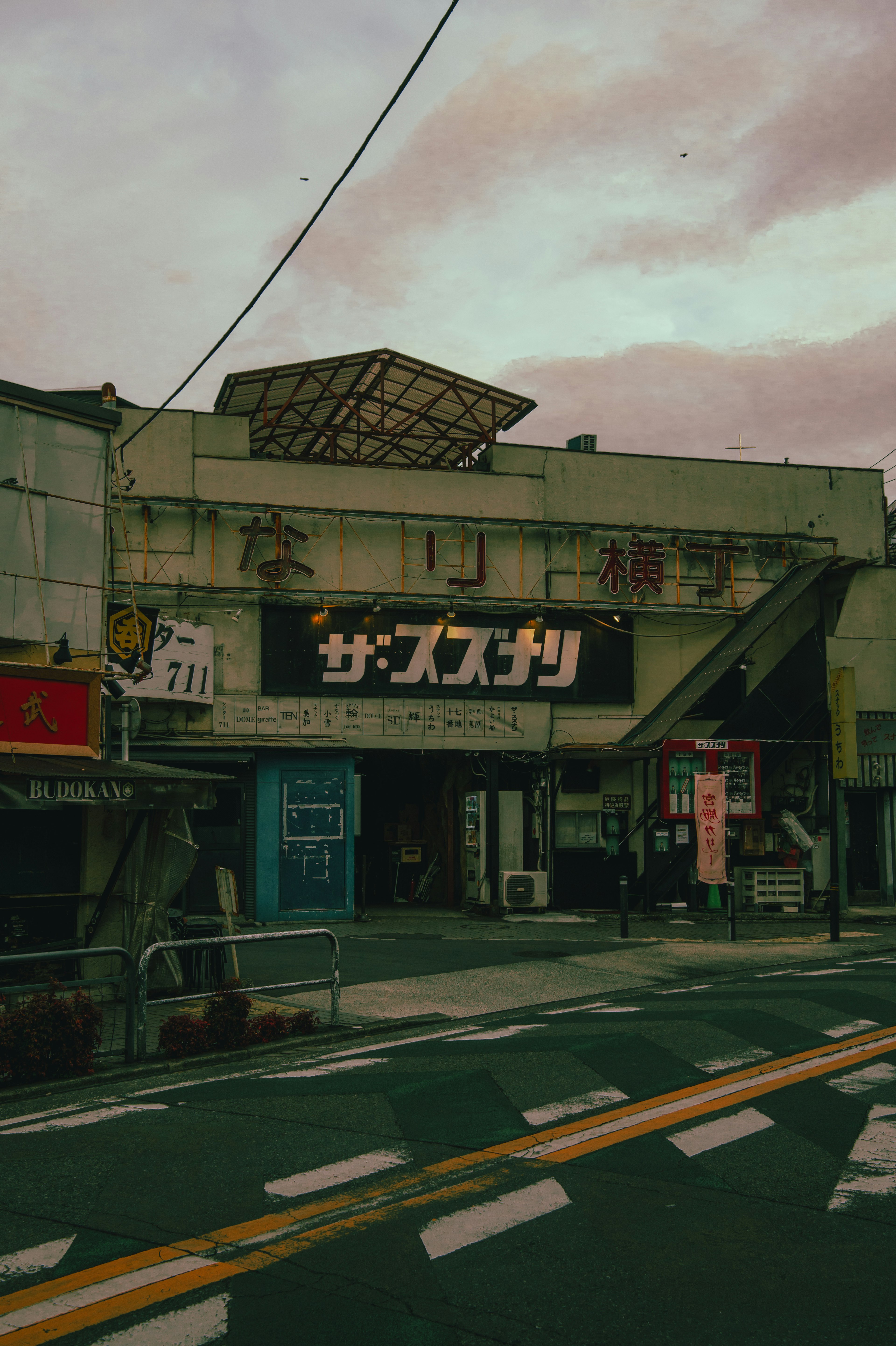 古い商業ビルの外観 昭和風の看板と薄暗い空の背景