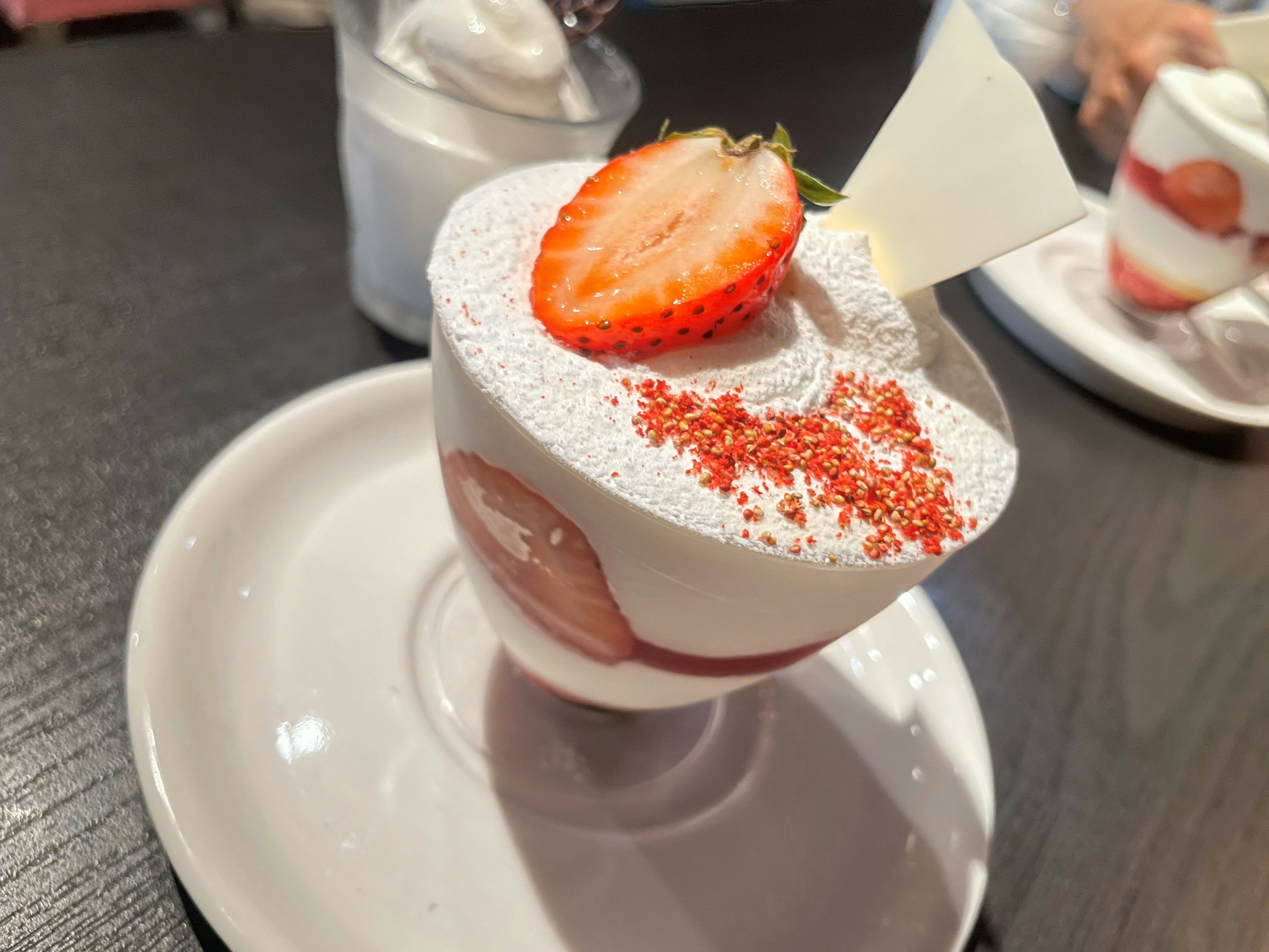 Creamy dessert topped with strawberries and decorative sprinkles