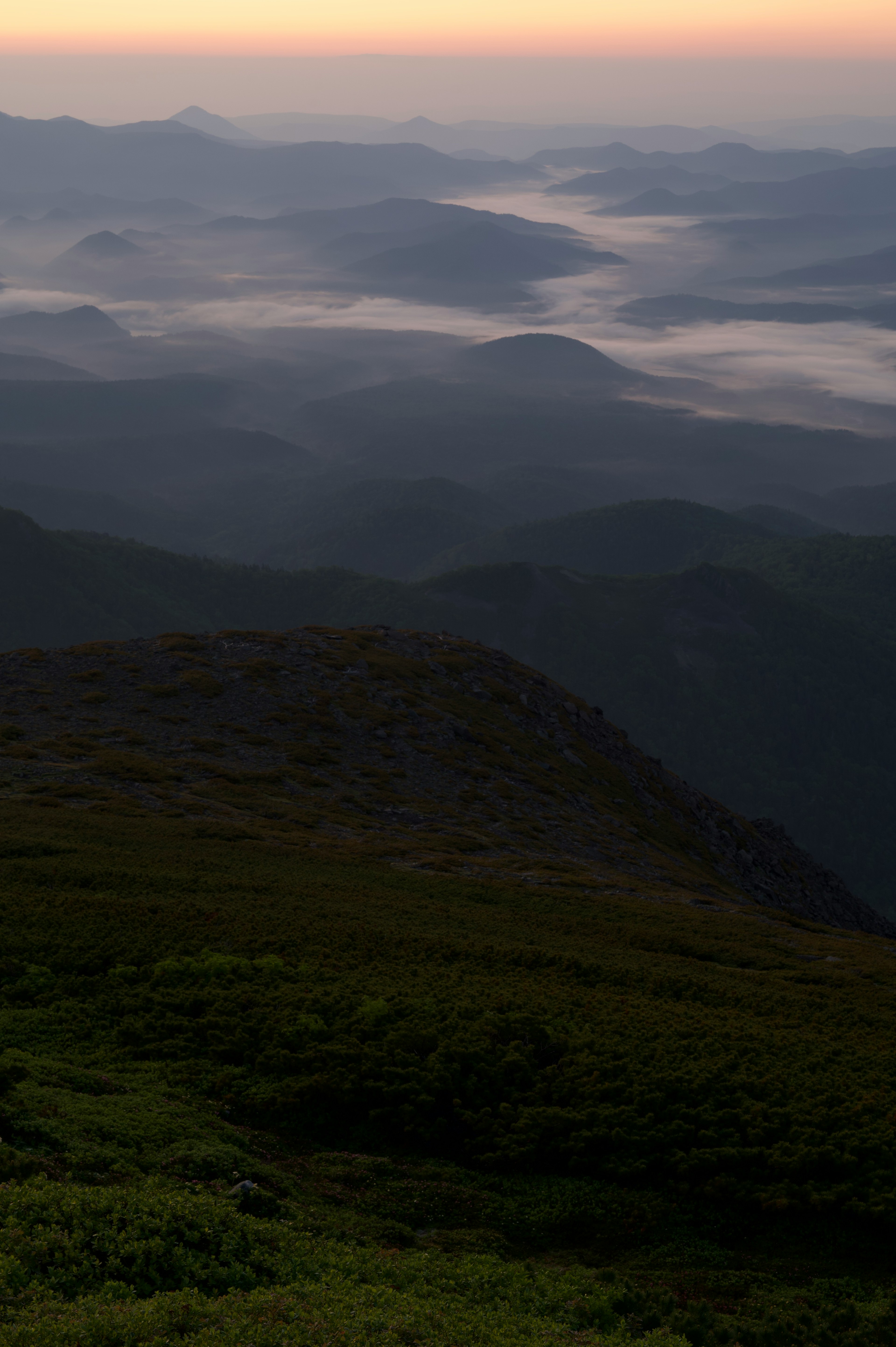 Scenic view of mountains and valleys shrouded in mist soft twilight light illuminating the landscape