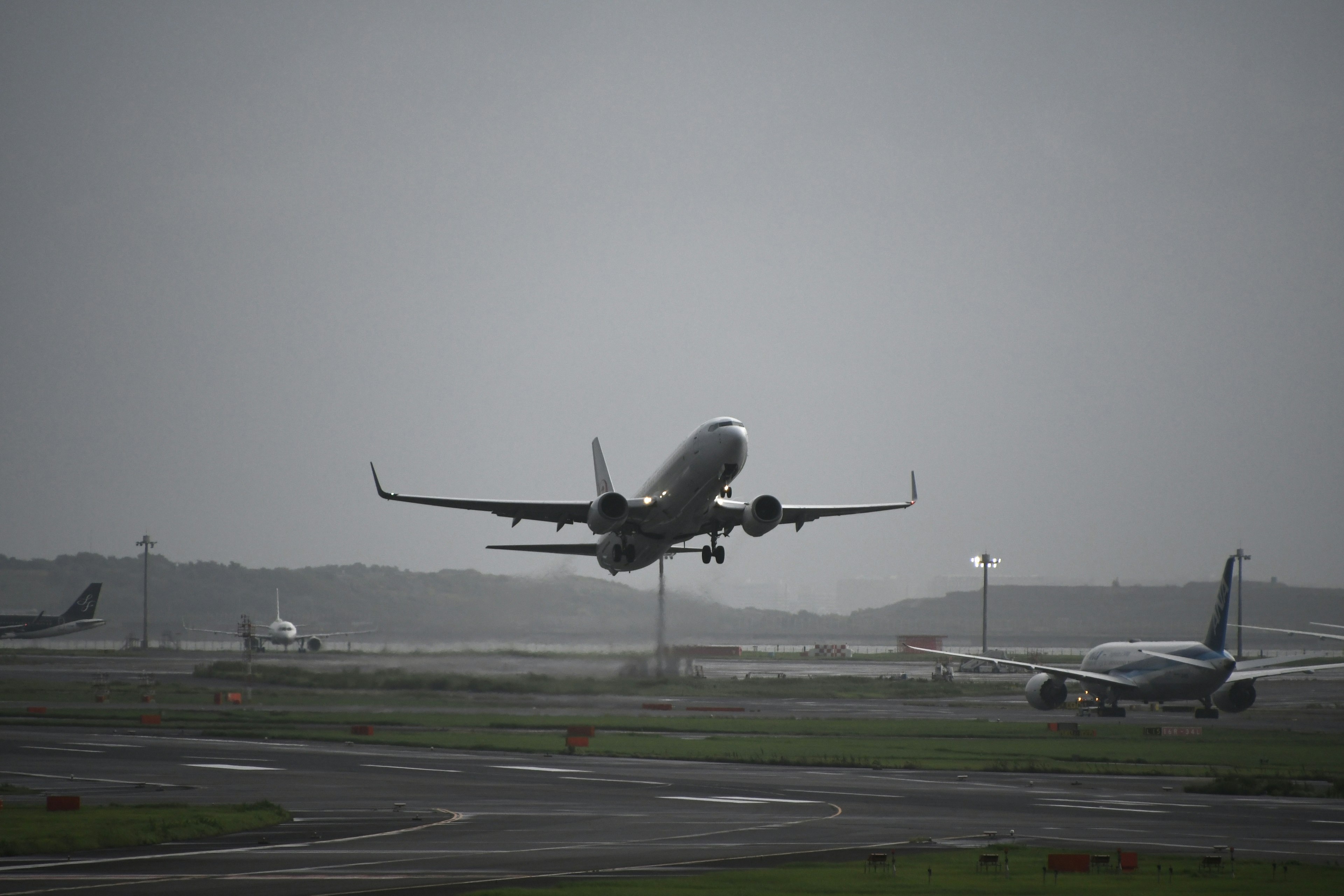 An airplane taking off at an airport under cloudy skies