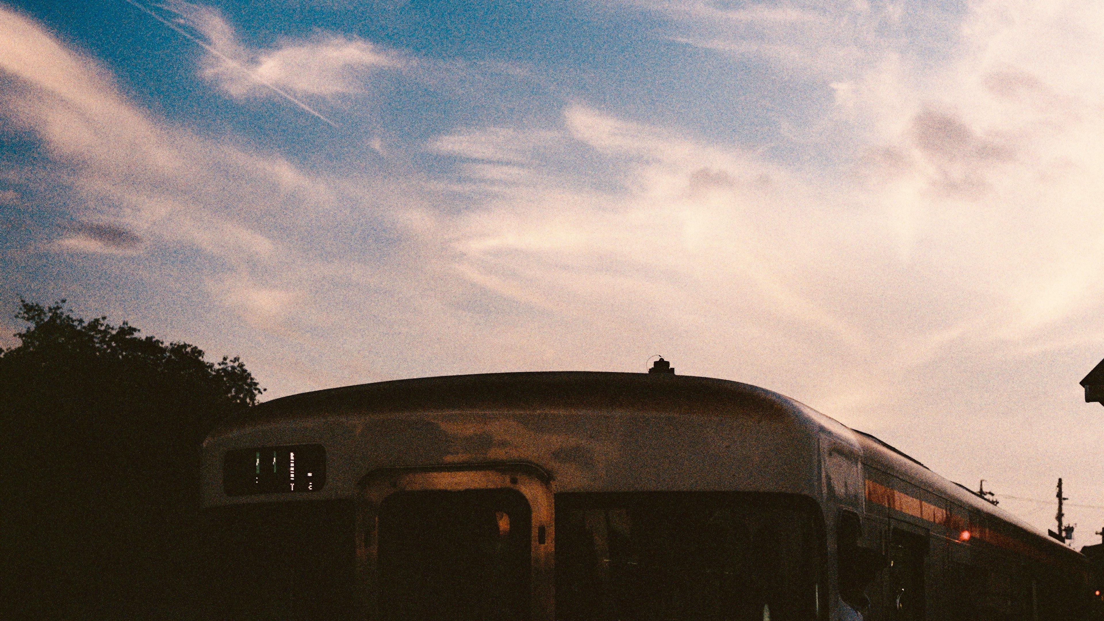 Train roof under a sunset sky