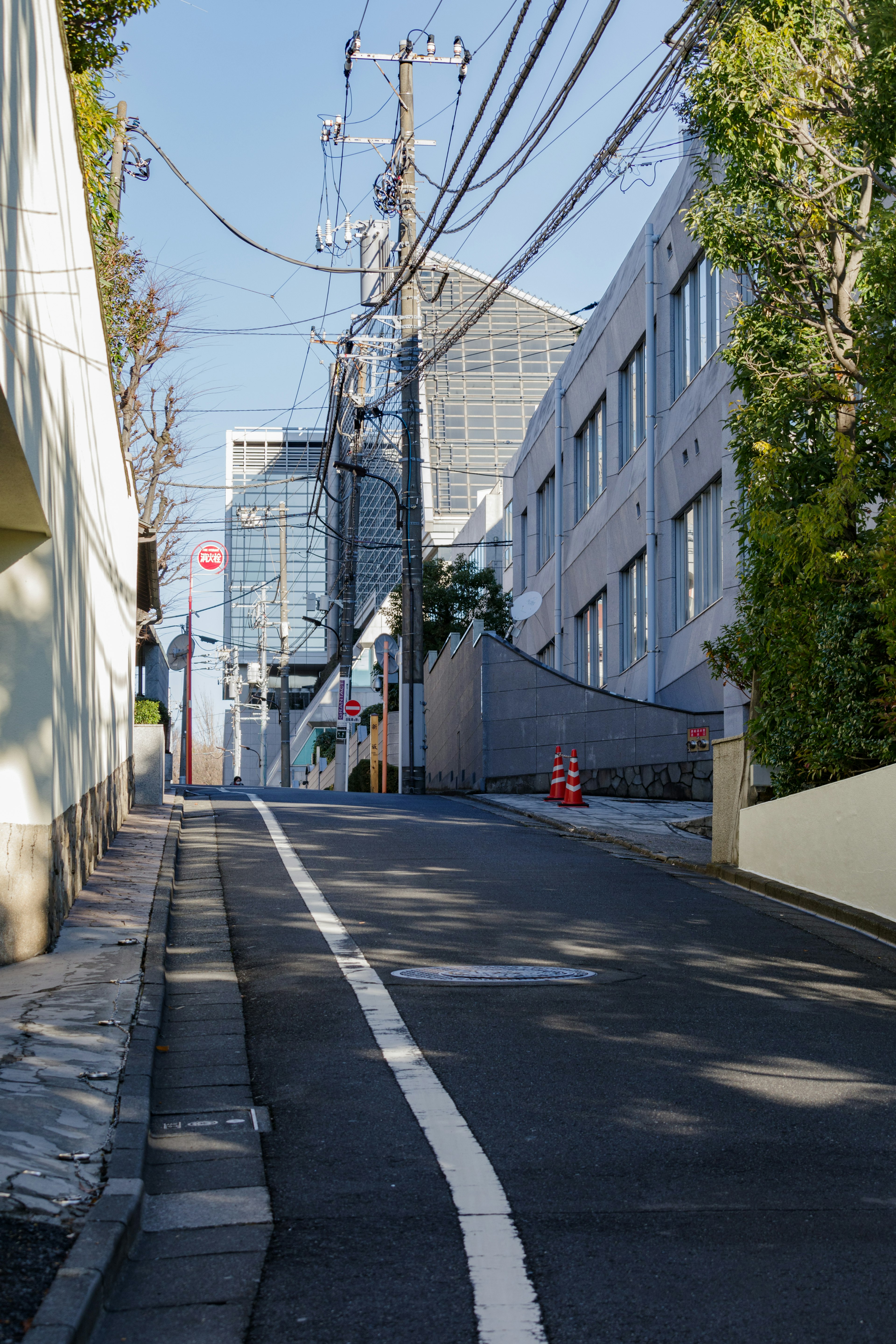 Sloped street with modern buildings and utility poles