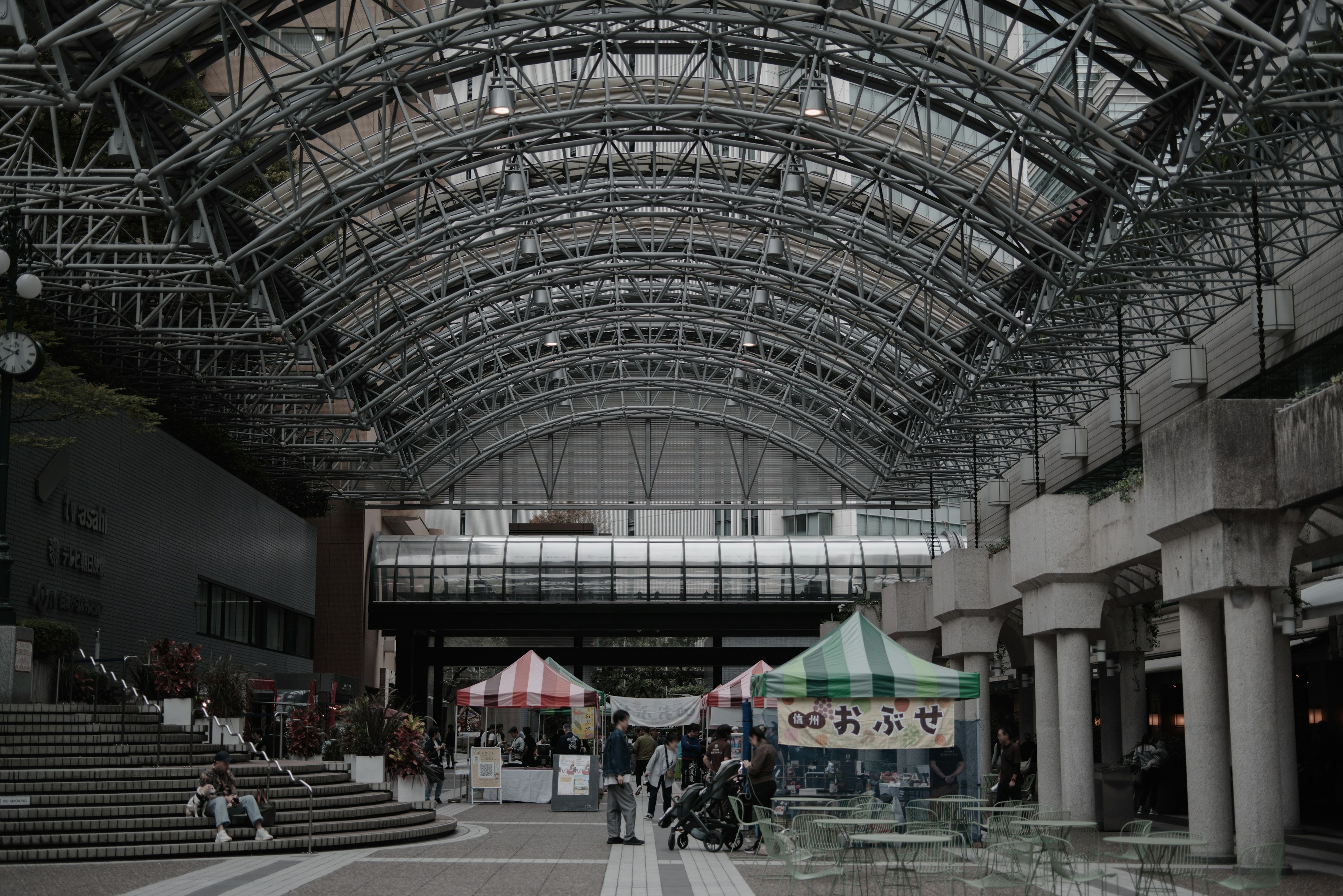 Spacious indoor area featuring an arching roof and vendor stalls