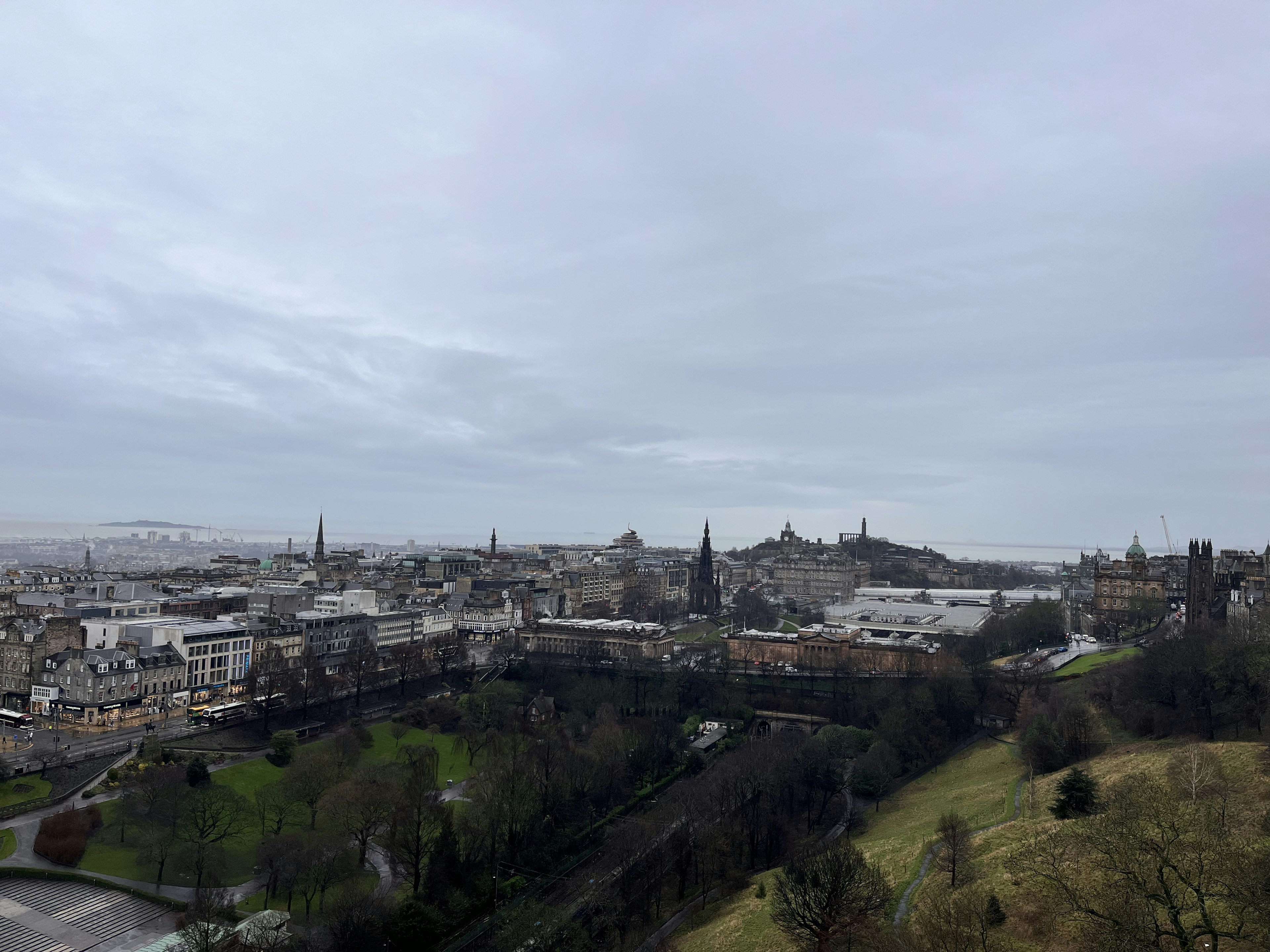 Pemandangan panorama Edinburgh pada hari mendung dengan taman hijau dan bangunan bersejarah